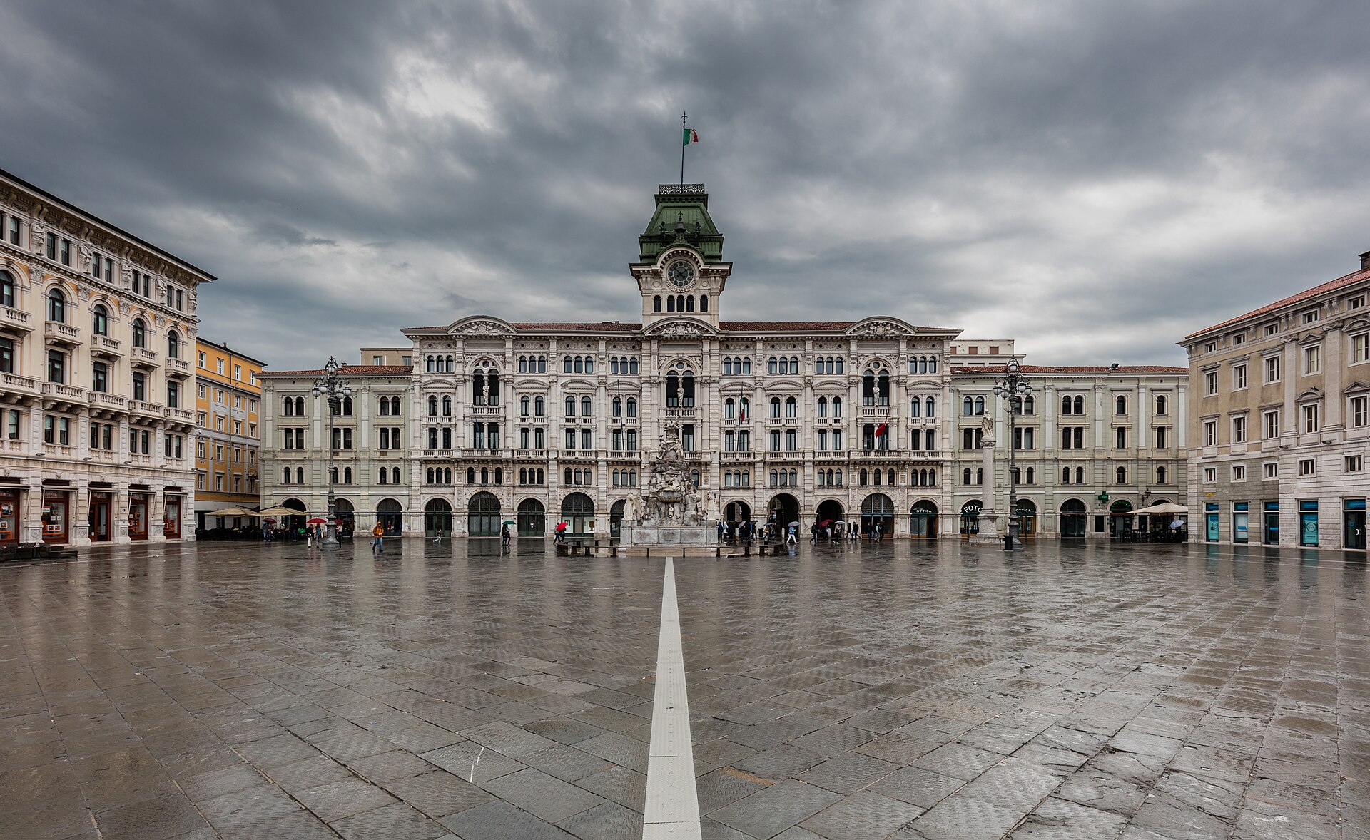 la piazza unita d italia de trieste con el ayuntamiento al fondo y el pavimento mojado