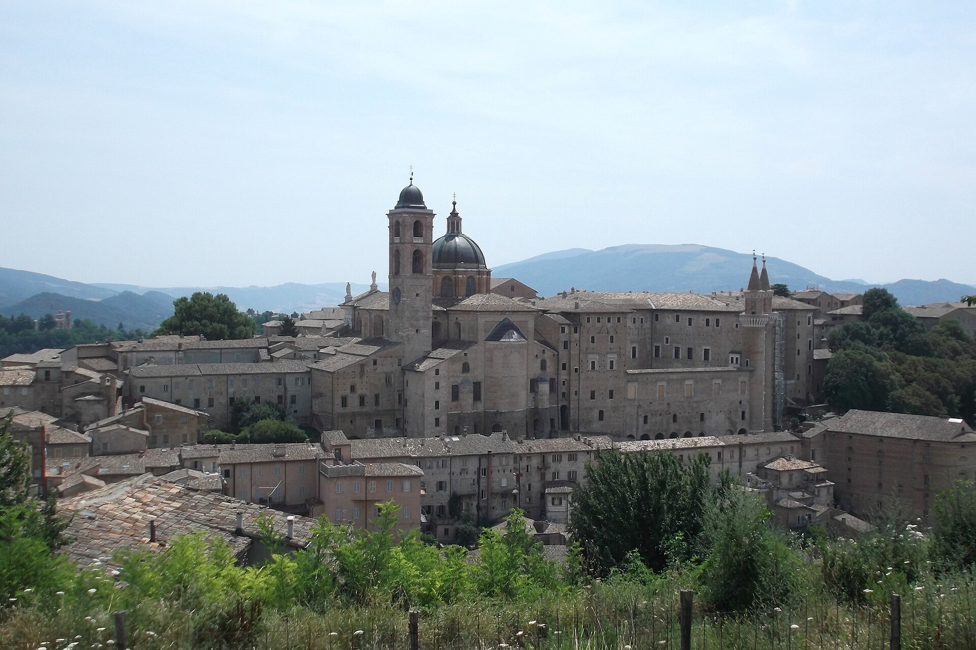 skyline d’urbino avec la coupole et le clocher de la cathédrale et la masse du palais ducal vues de l’extérieur des remparts