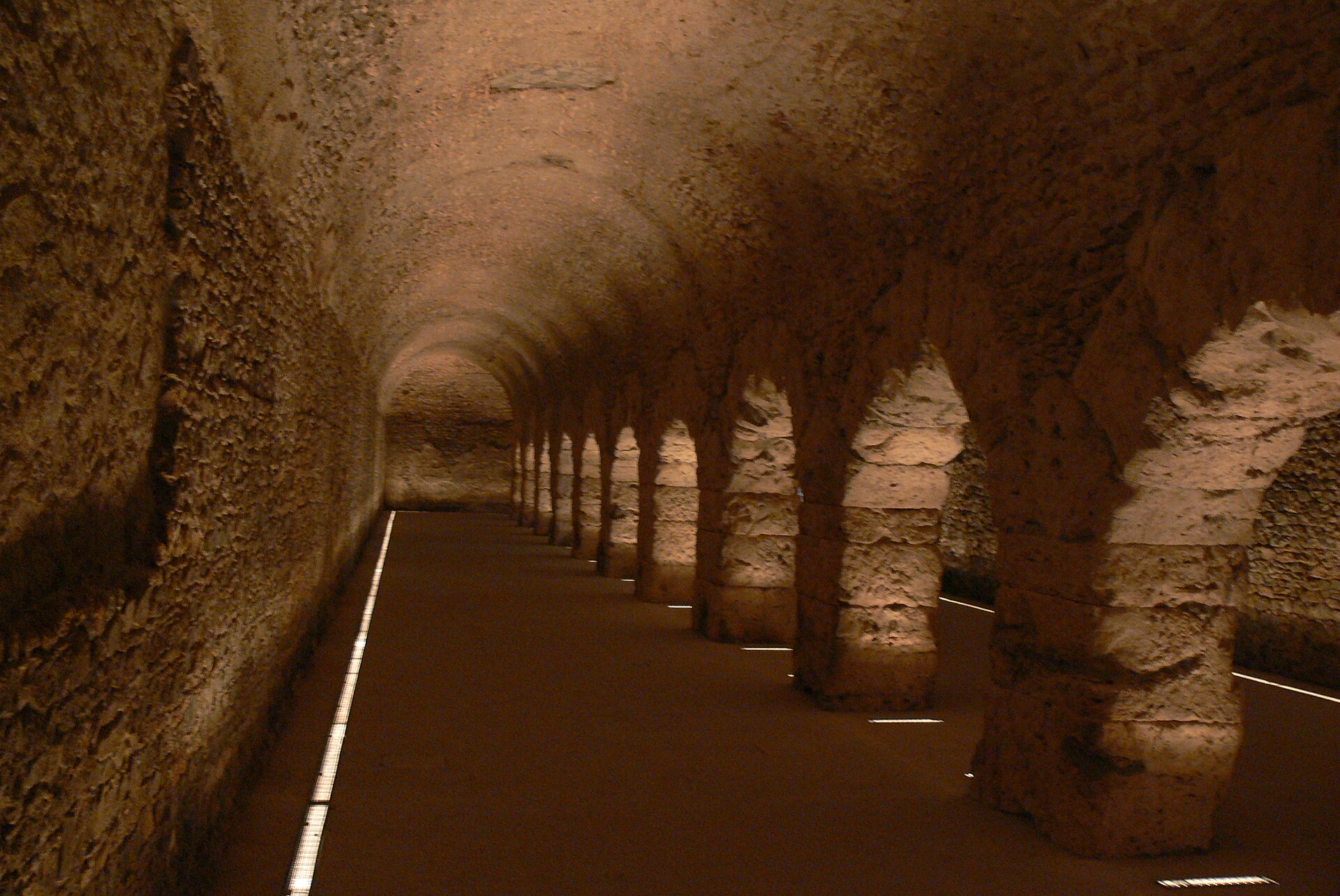 il criptoportico forense di aosta, galleria sotterranea con volte a botte e piloni illuminati da luce calda