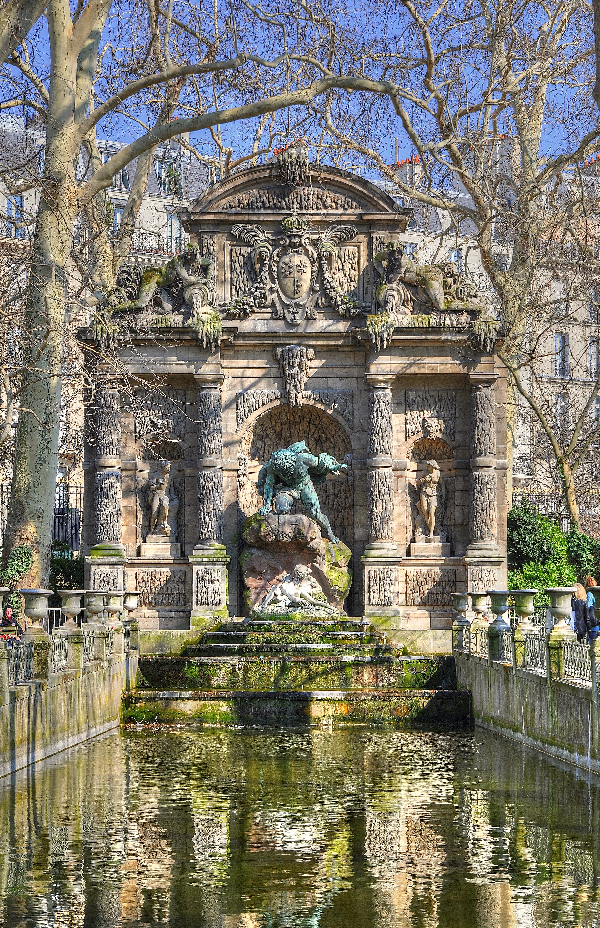 la fontana medici del giardino del lussemburgo a parigi, con la lunga vasca d acqua verde fra due file di vasi di pietra e il gruppo di bronzo di polifemo sopra aci e galatea nella nicchia in fondo