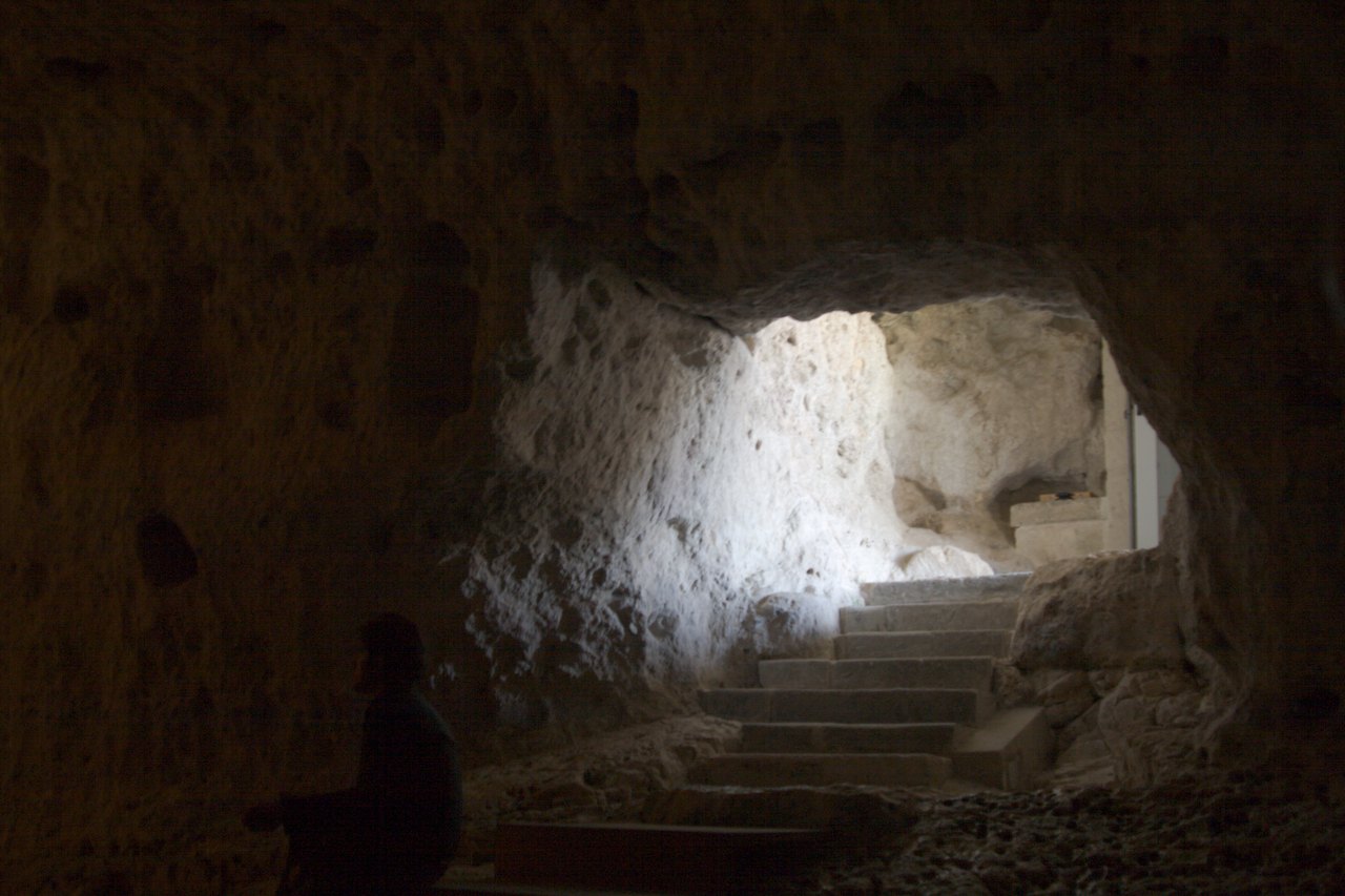 l entree de la crypte du peche originel creusee dans la roche avec l escalier qui descend vers la grotte