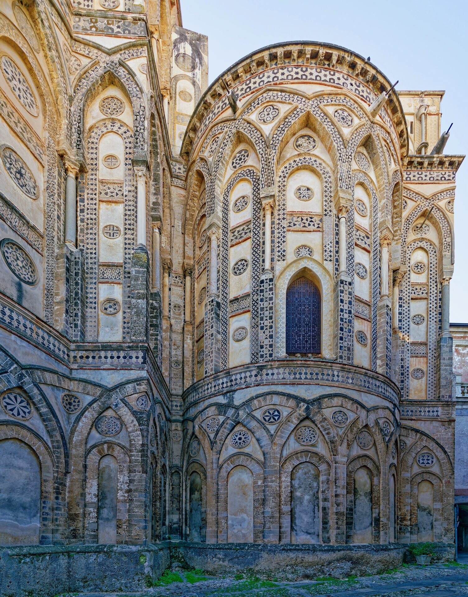 the exterior of monreale cathedral with apses decorated in interlacing arcading and lava stone inlay