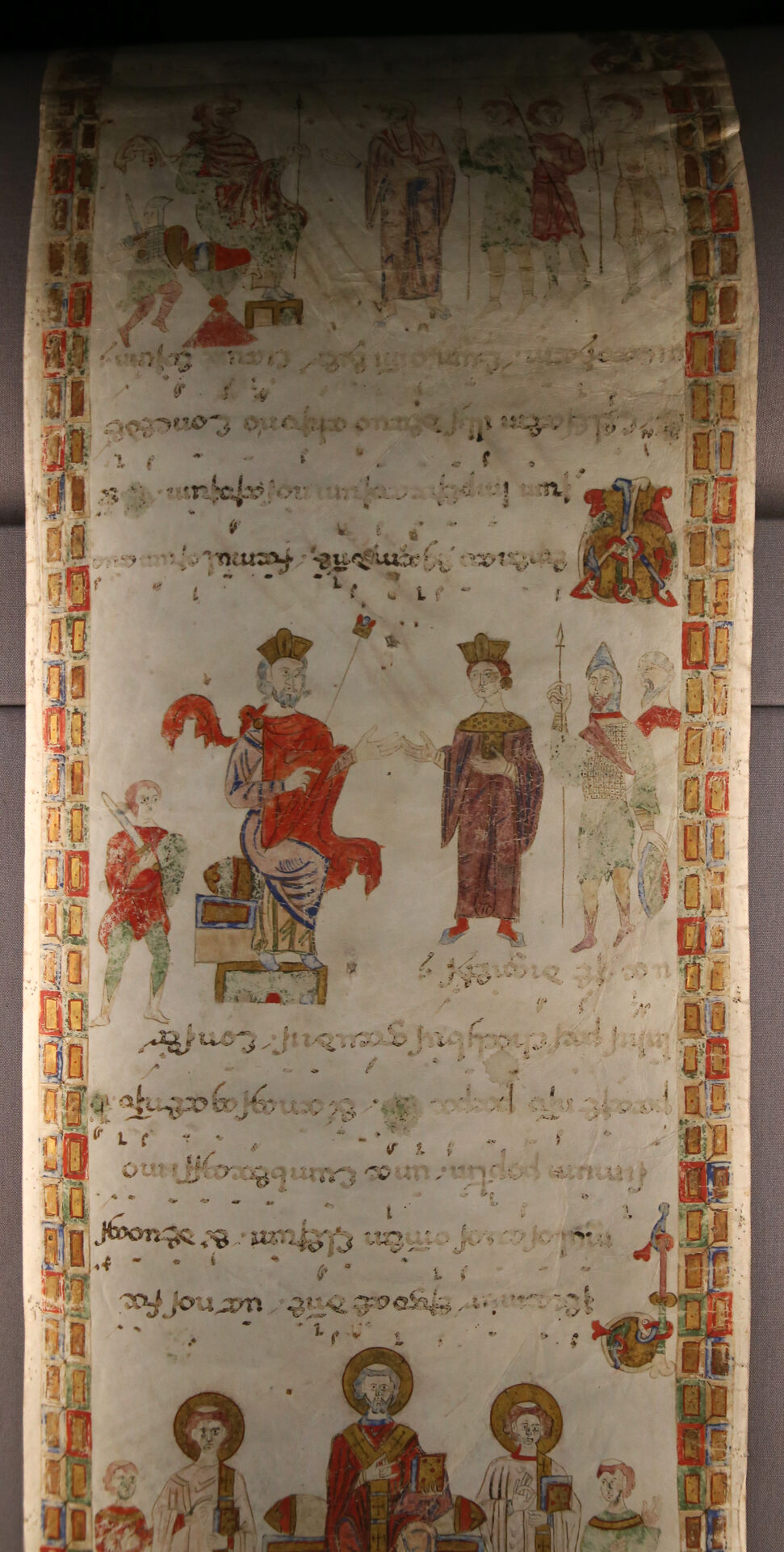 a beneventan exultet scroll unrolled, its miniatures upright and the text upside down along its whole length