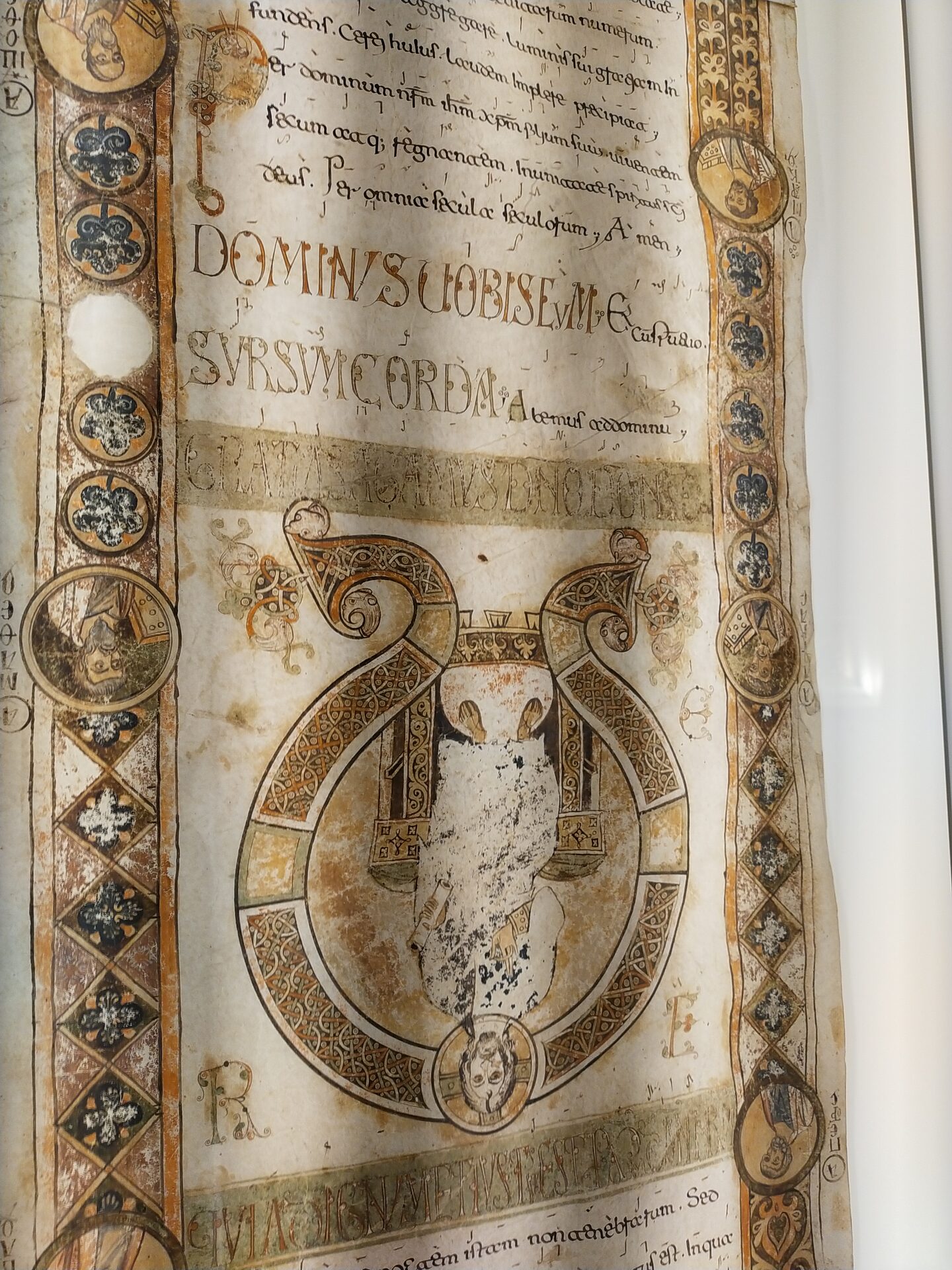 an exultet scroll displayed in the case of the diocesan museum of bari with the words dominus vobiscum and sursum corda