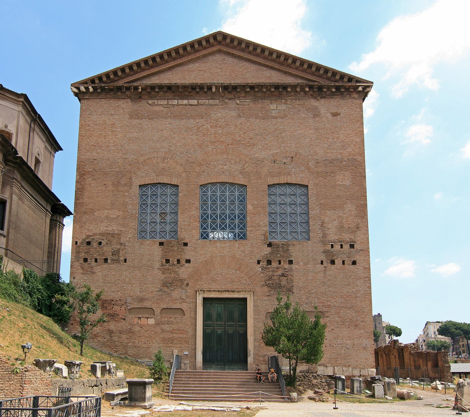 la facciata in mattoni della Curia Iulia nel Foro Romano, con il timpano e le tre grandi finestre