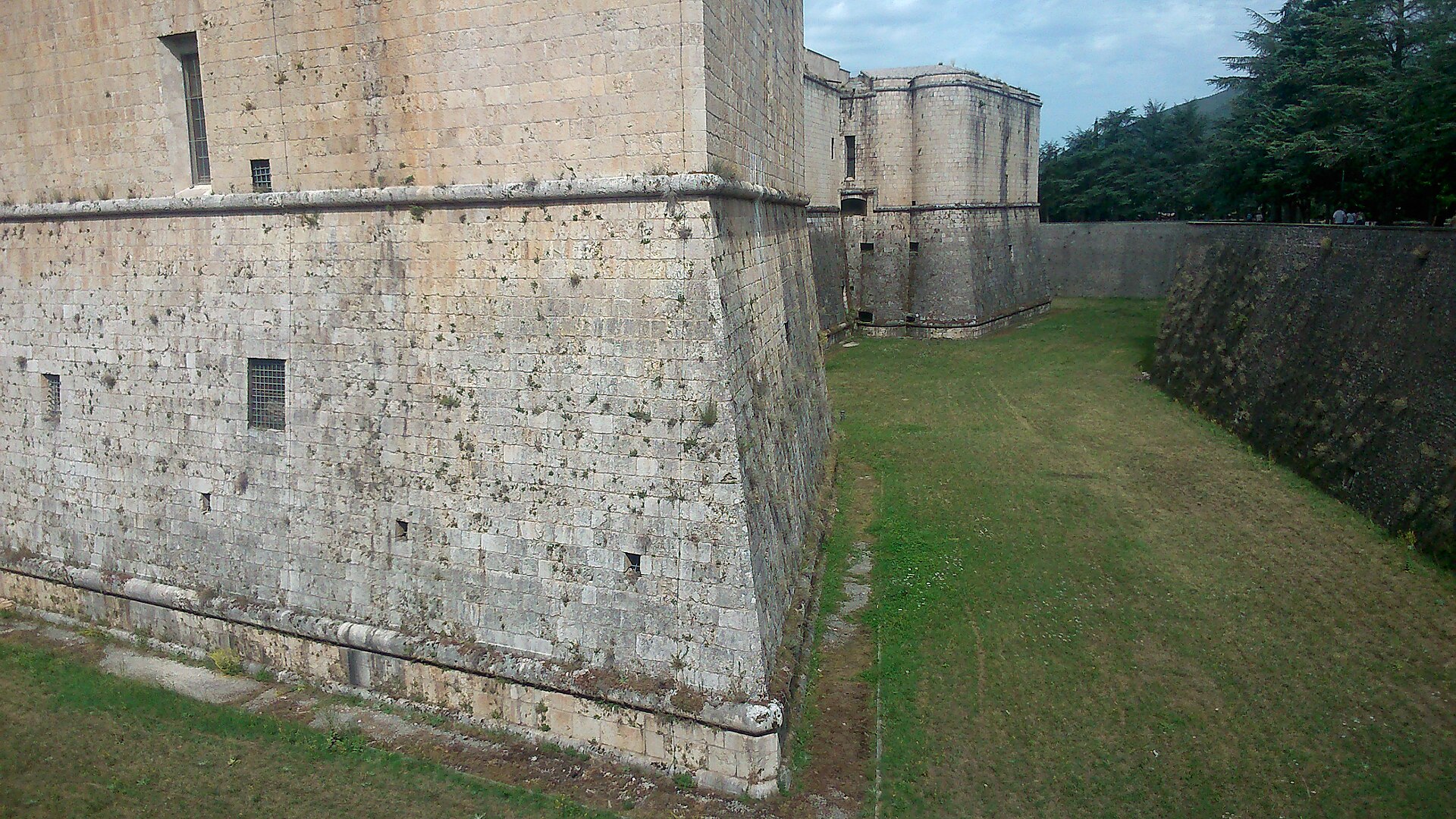 il muro scarpato di un bastione del forte spagnolo dell aquila con il fossato asciutto erboso e la controscarpa