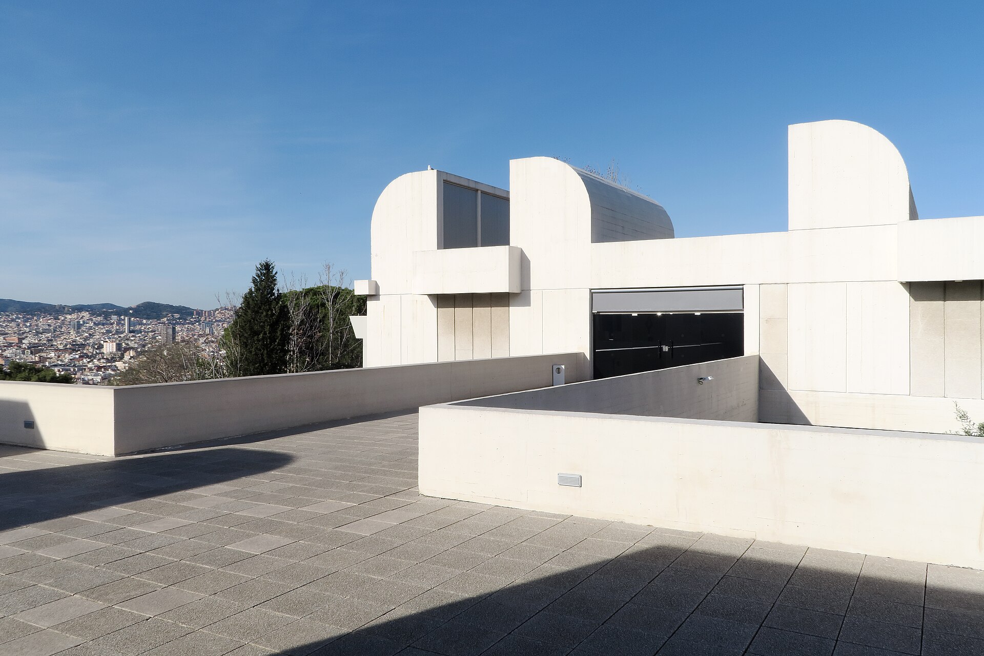 le terrazze bianche della fundacio joan miro con i grandi lucernari curvi di cemento e barcellona sullo sfondo