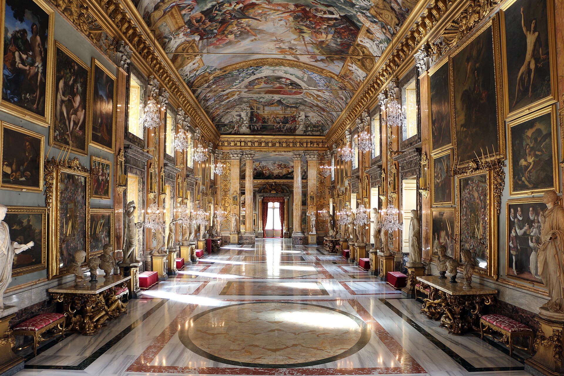 la sala grande della galleria colonna vista in lunghezza, con il pavimento di marmo, i quadri alle pareti dorate e la volta affrescata
