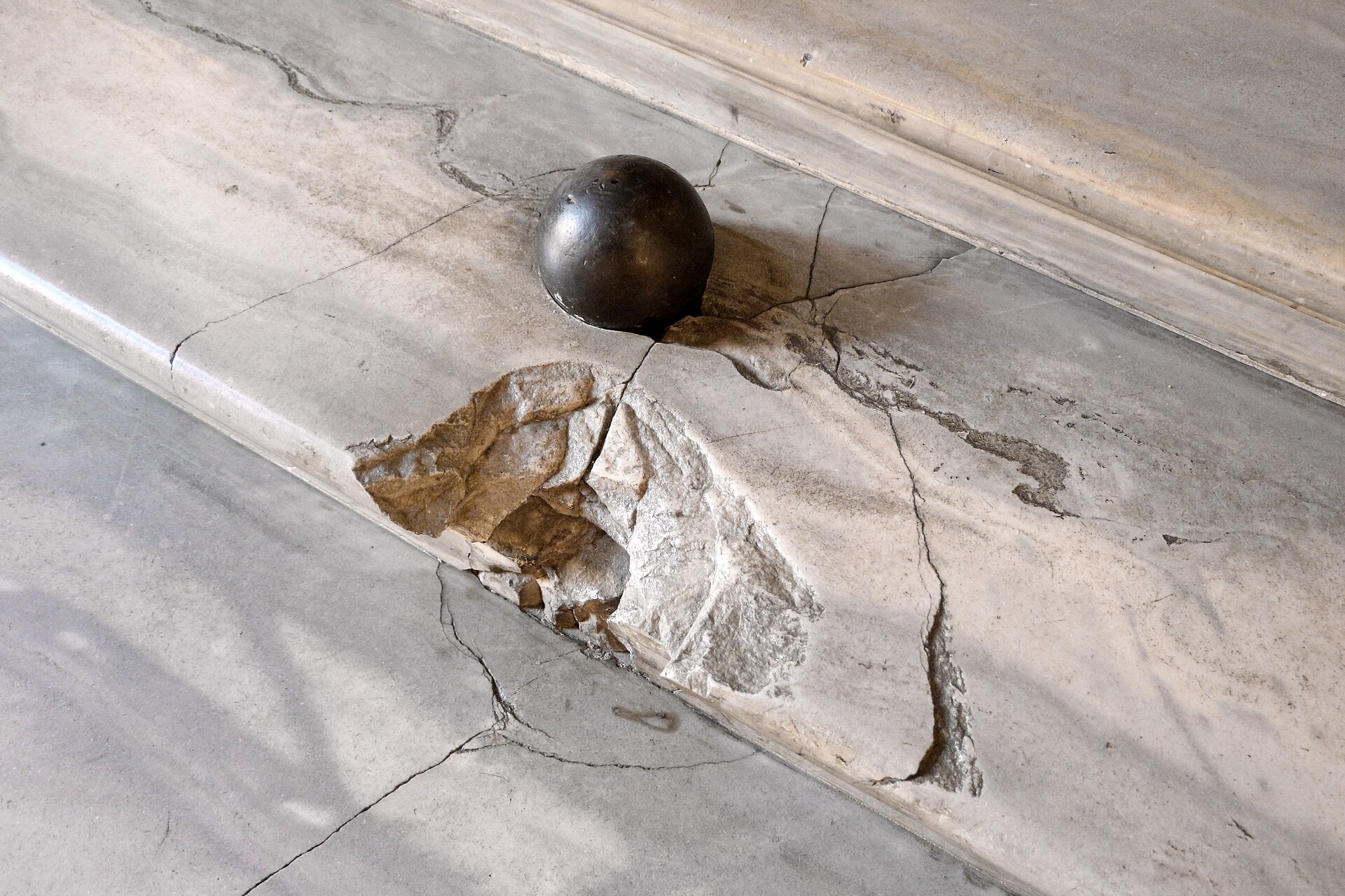 la palla di cannone del 1849 ancora appoggiata sul gradino di marmo della galleria colonna, accanto alla scheggiatura lasciata dal colpo