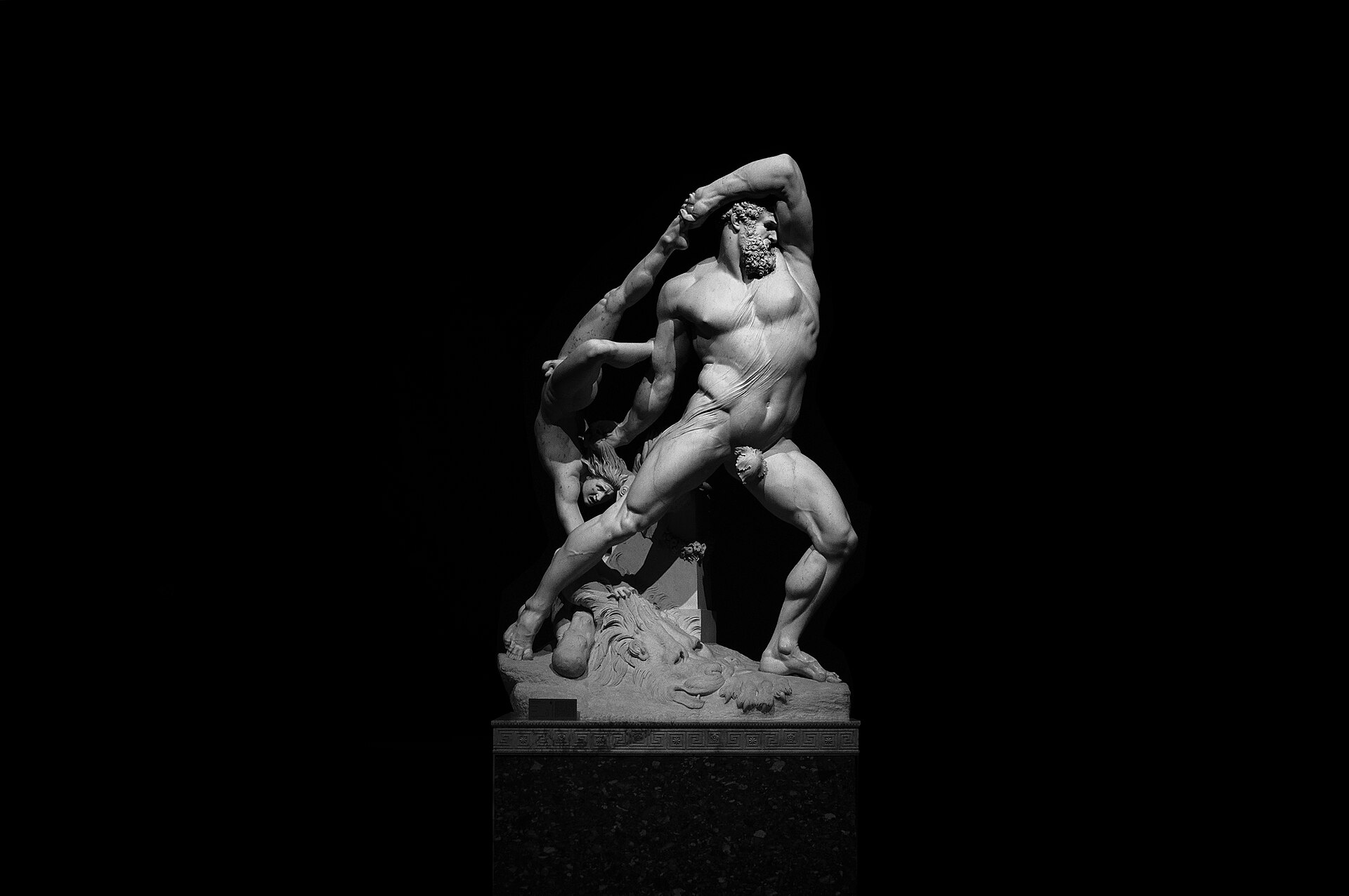 il gruppo marmoreo di ercole e lica di canova su fondo nero, con ercole che solleva il ragazzo per una gamba e per i capelli