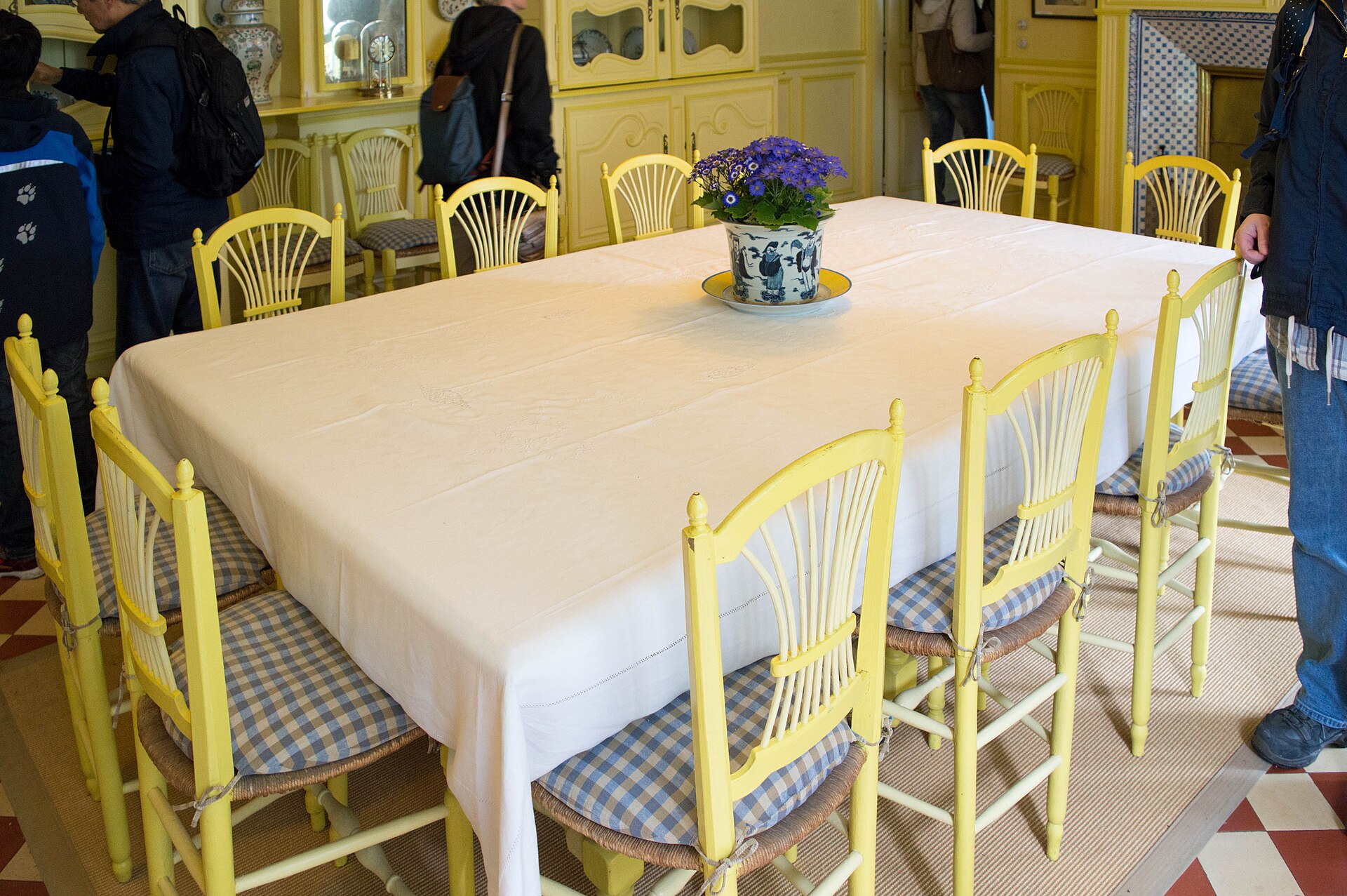 la sala da pranzo gialla della casa di monet a giverny, con la lunga tavola apparecchiata, le sedie gialle e le credenze con le porcellane blu e bianche
