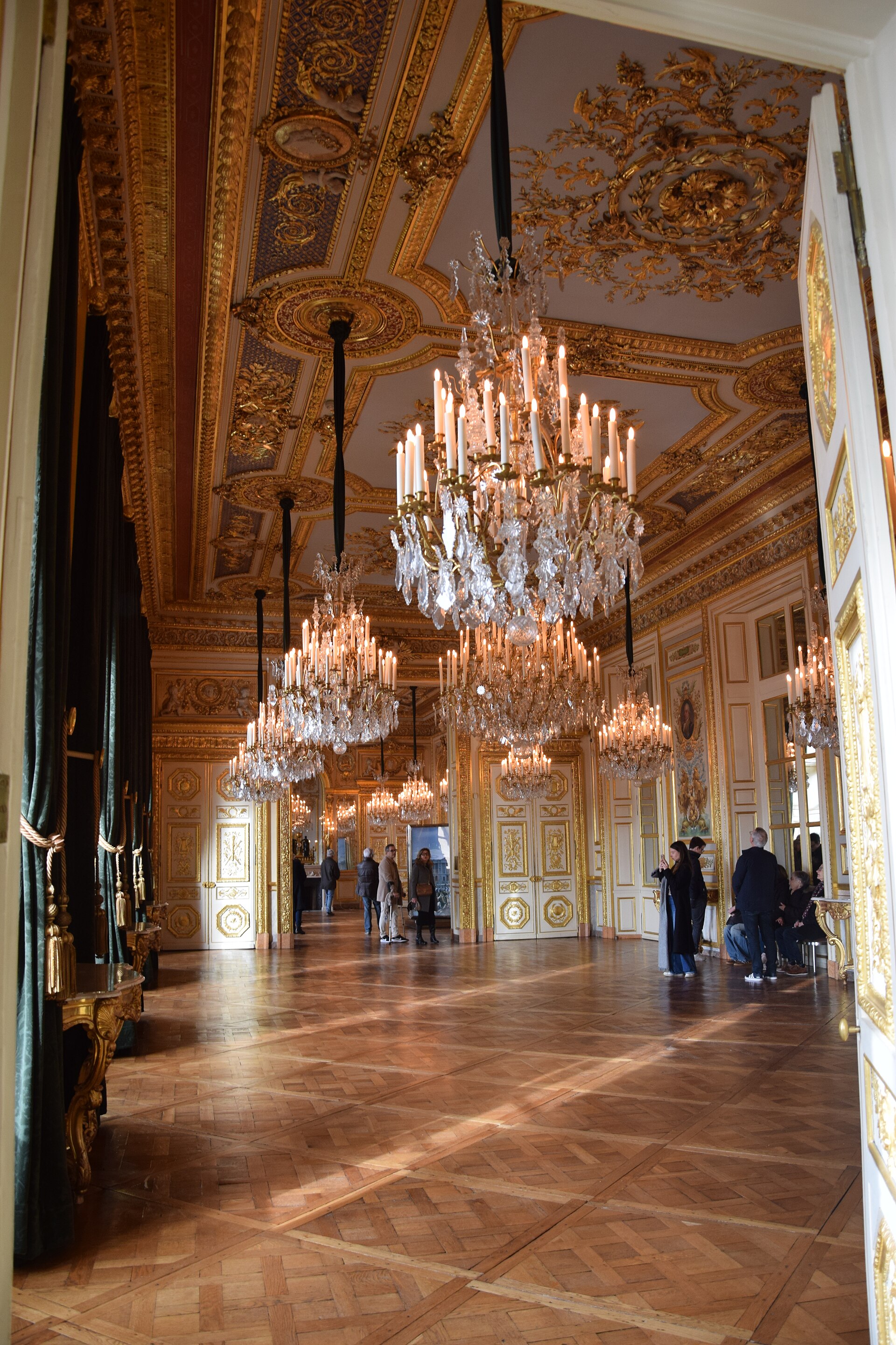 la galleria dorata dell hotel de la marine con la fila di lampadari di cristallo accesi e il parquet a riquadri