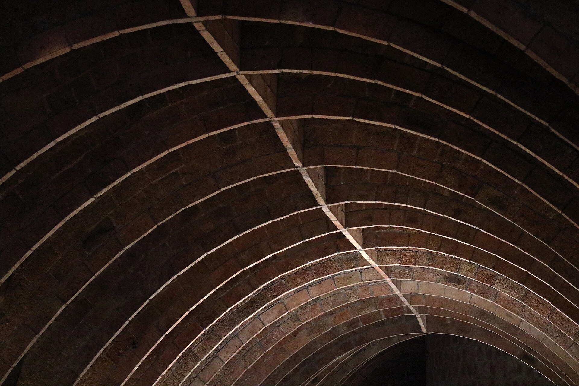 la soffitta della pedrera con gli archi di mattoni a catenaria che si susseguono