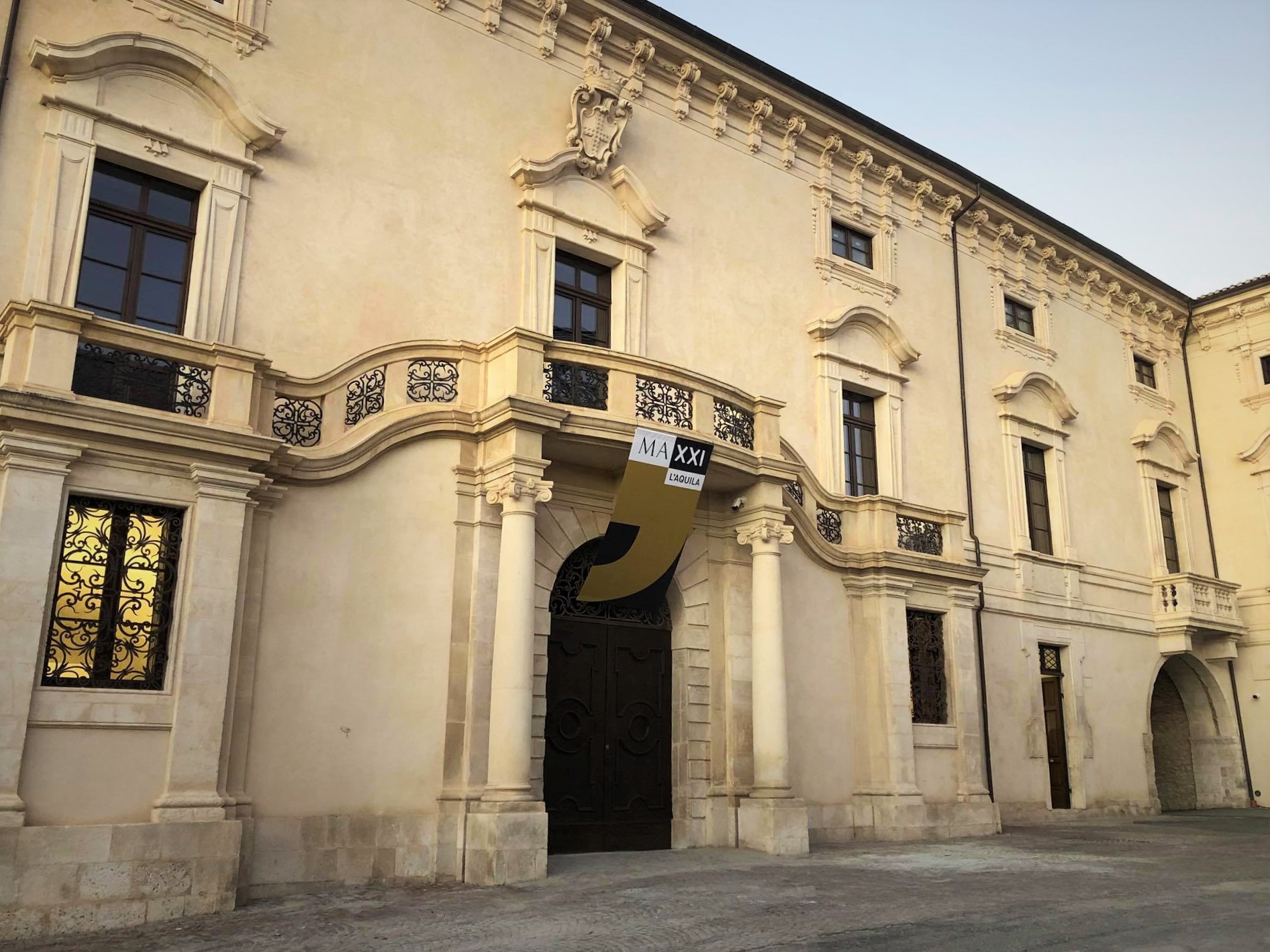 la facciata restaurata di palazzo ardinghelli all aquila con il balcone a serpentina e lo stendardo del maxxi