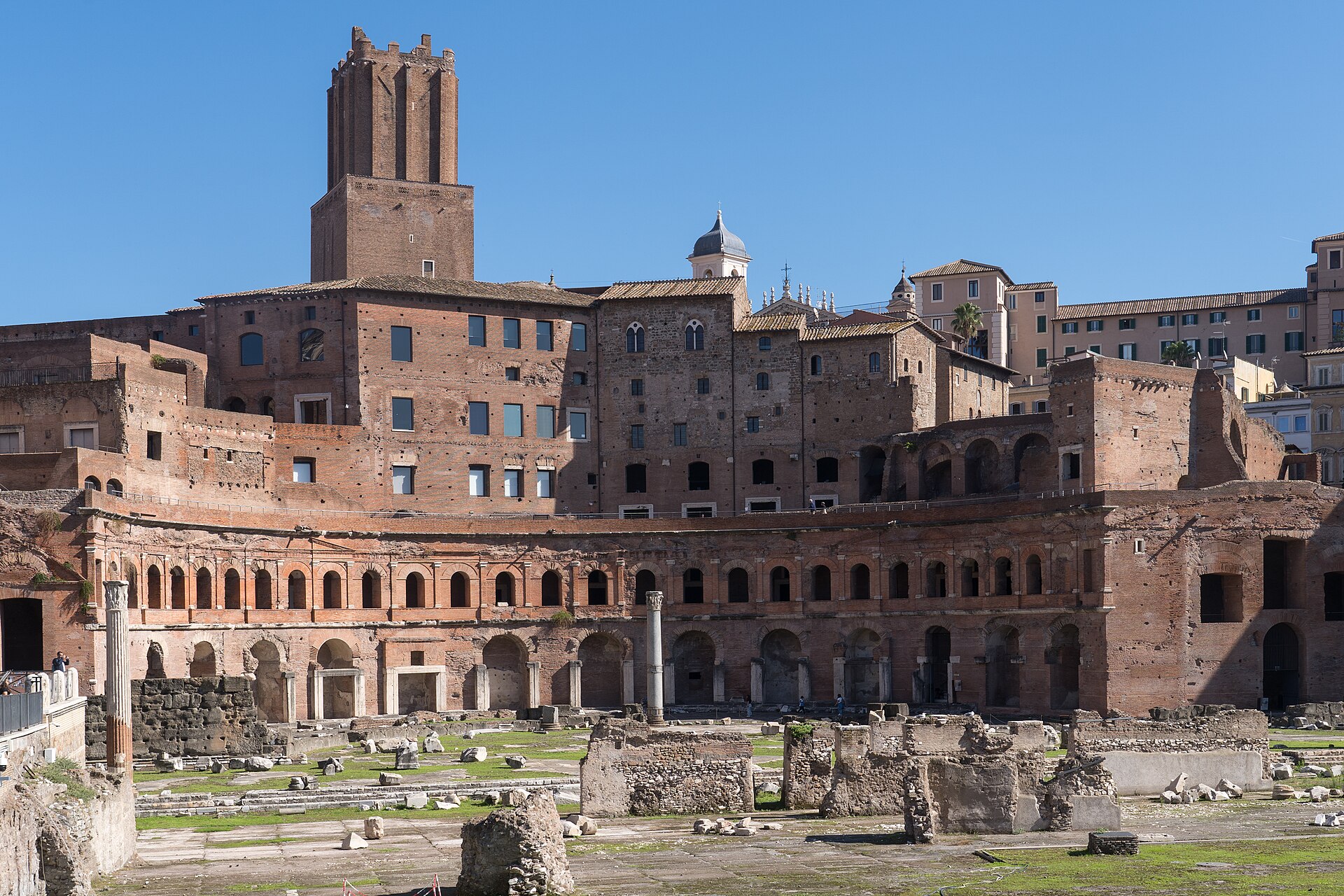 l’emiciclo dei mercati di traiano a roma visto dal foro, con la torre delle milizie in alto e le arcate in laterizio su due ordini