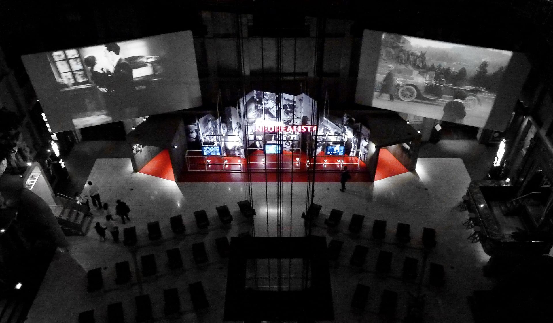 the aula del tempio at the national museum of cinema seen from above, with red loungers arranged in a circle and the large screens