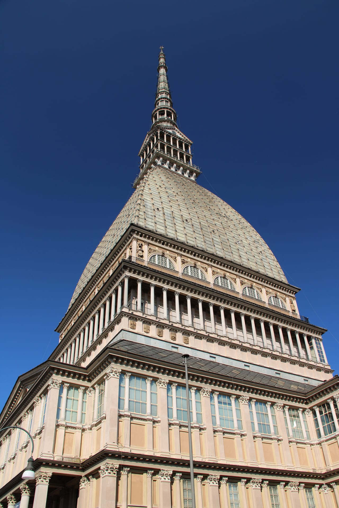 the spire of the mole antonelliana seen from below, with its stacked colonnades and the final pinnacle