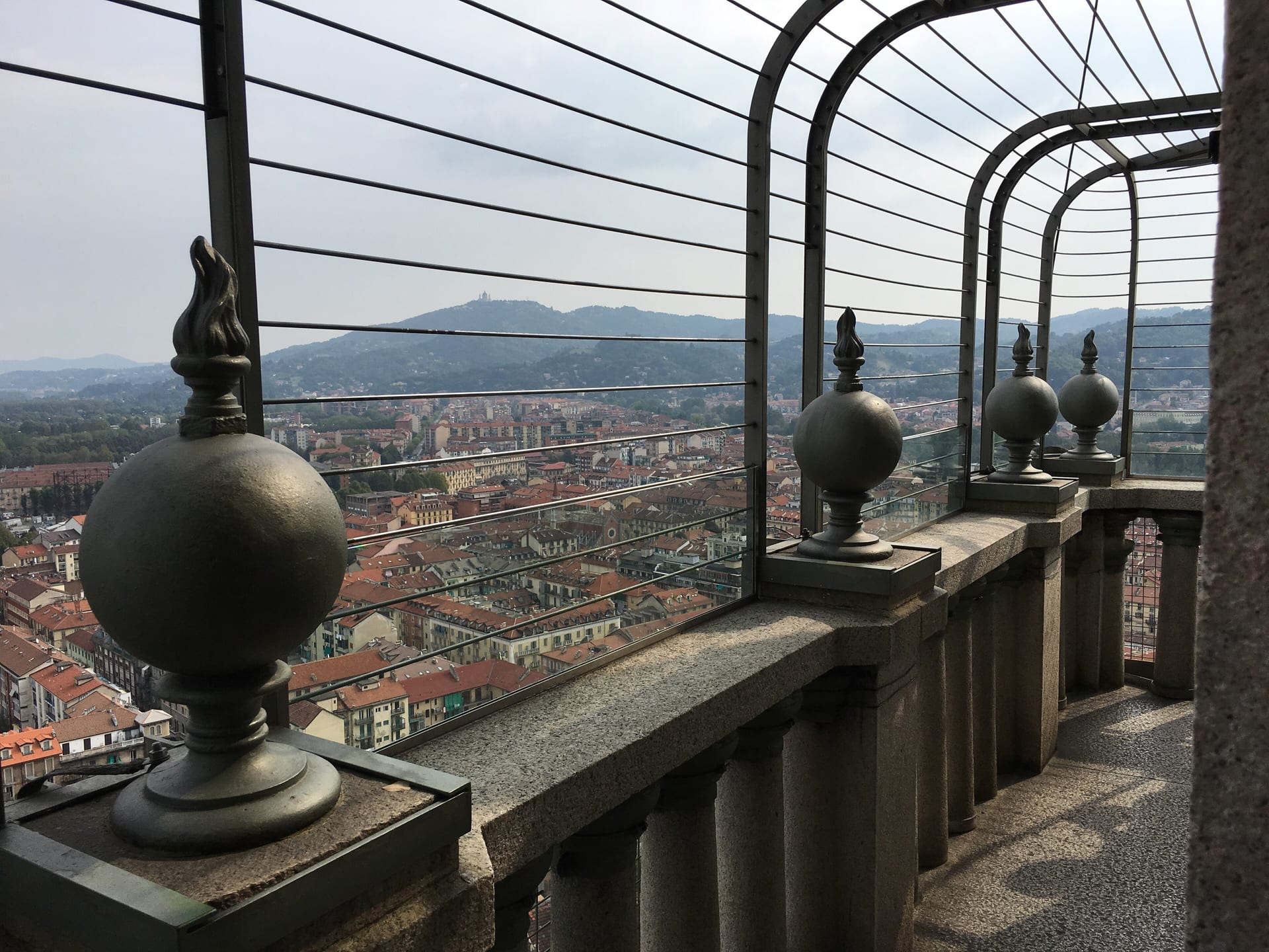 the balcony of the mole antonelliana tempietto at eighty five metres, with the city and the hill of superga in the distance