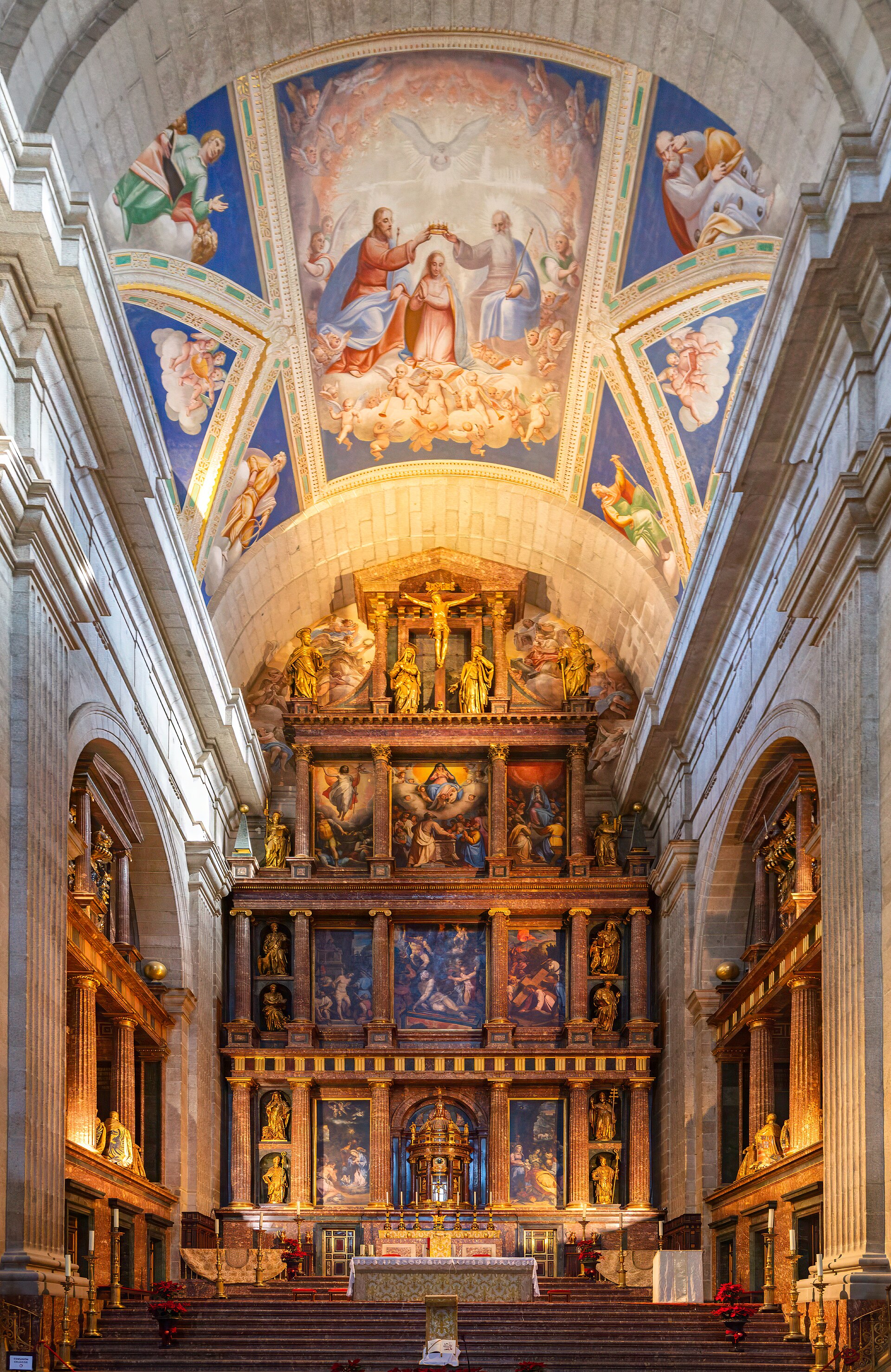 il presbiterio della basilica dell’escorial, con il grande retablo dorato a più ordini di dipinti e statue, gli affreschi sulla volta e i gradini di marmo davanti all’altare