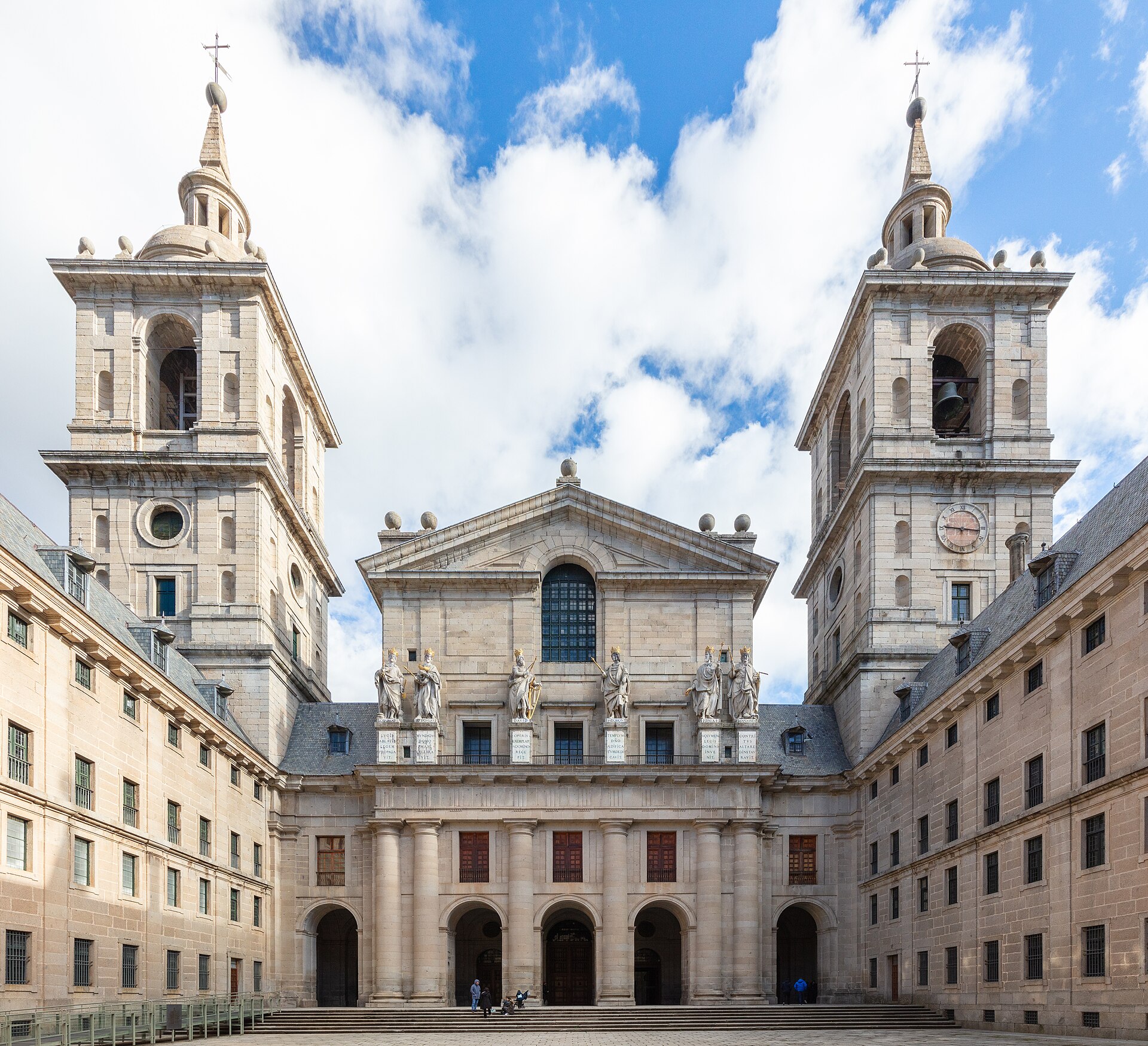 il patio de reyes dell’escorial, con la facciata della basilica fra due campanili, le statue sopra il portico e il cortile lastricato davanti