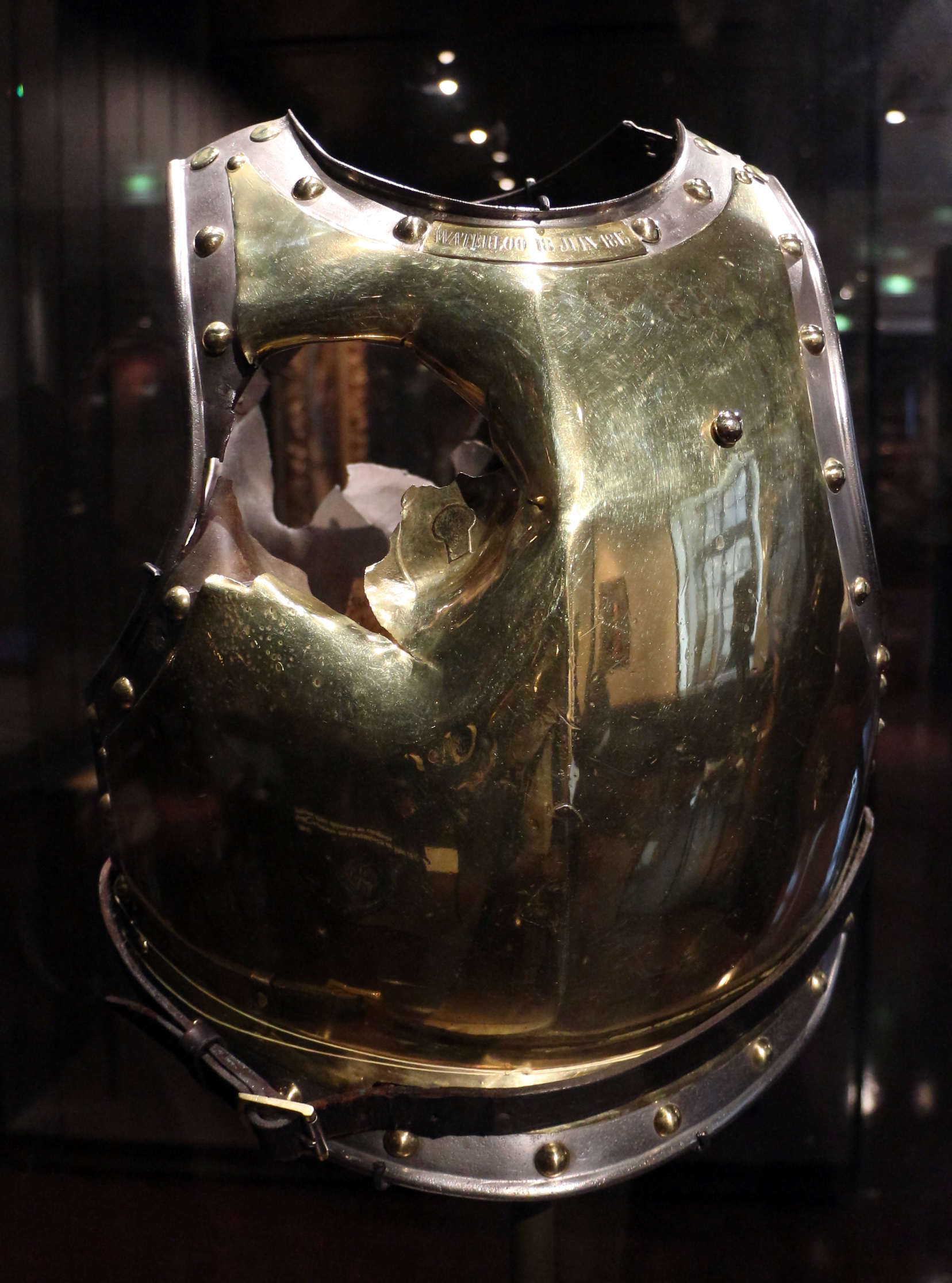 la cuirasse de laiton du carabinier antoine fauveau dans une vitrine du musee de l armee, avec un grand trou ouvert par le boulet de canon a waterloo