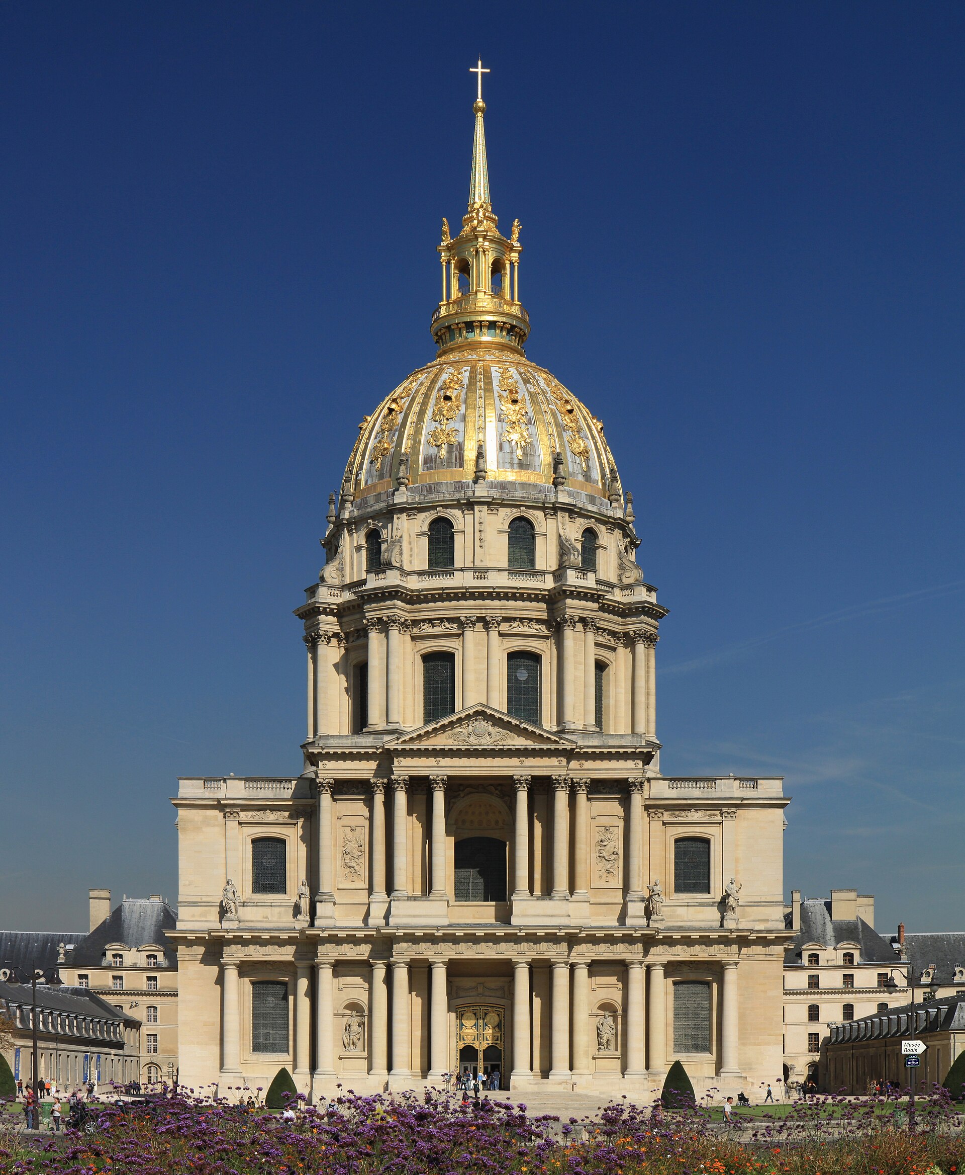 la facade du dome des invalides vue de la place vauban, avec les colonnes, la coupole doree et la lanterne surmontee d une croix sous le ciel bleu