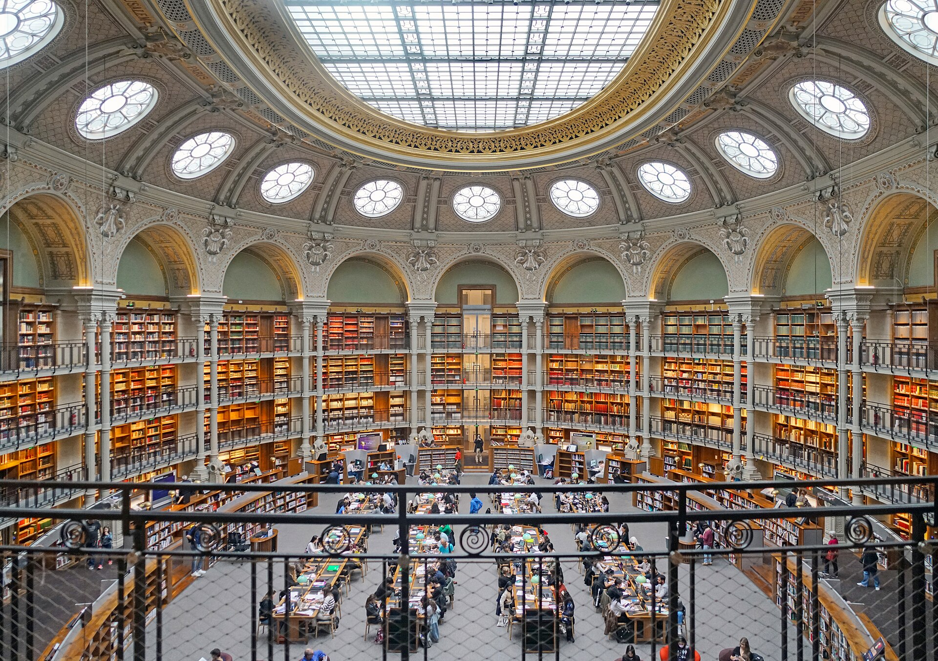 la salle ovale vista dall alto, con la grande vetrata ovale al centro del soffitto, la corona di oculi rotondi intorno e gli scaffali di libri su due livelli sopra i tavoli di lettura