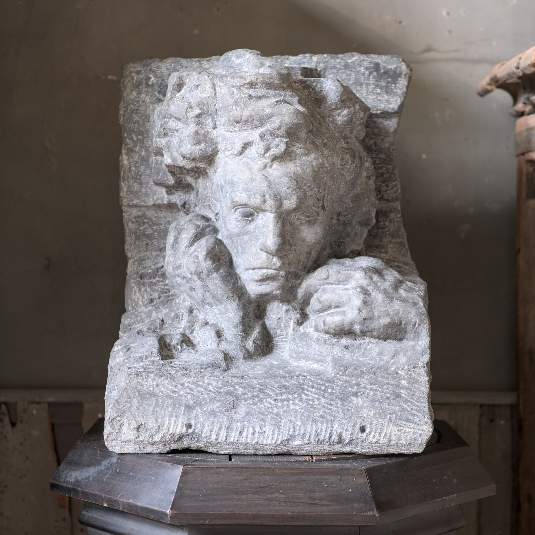 le beethoven sculpte dans la pierre par bourdelle, la tete aux cheveux en desordre qui emerge du bloc brut avec un poing contre le menton et l autre pose sur le rebord