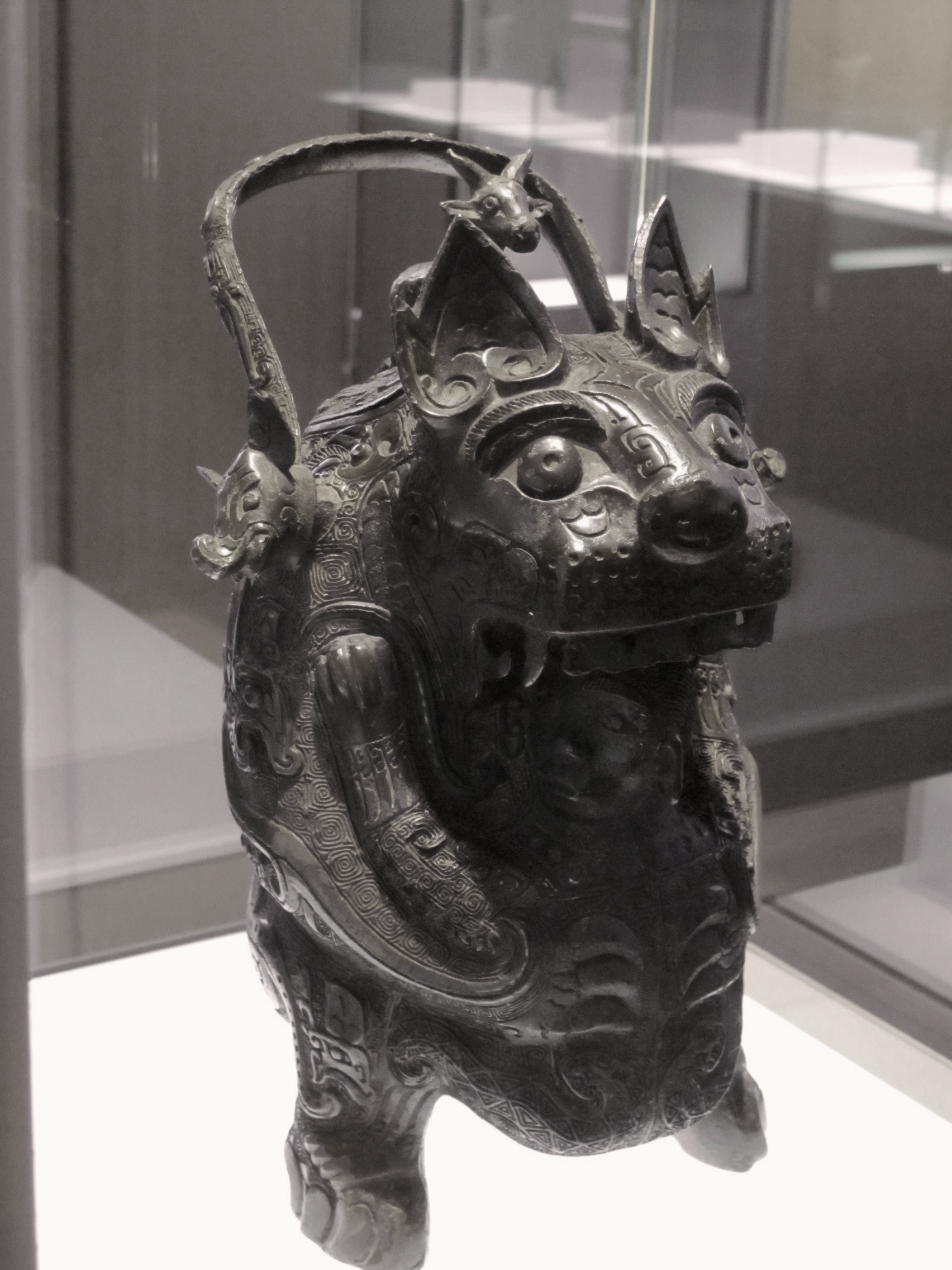 il vaso you detto la tigresse, bronzo cinese a forma di animale accovacciato con occhi sporgenti e ansa ad arco, in vetrina