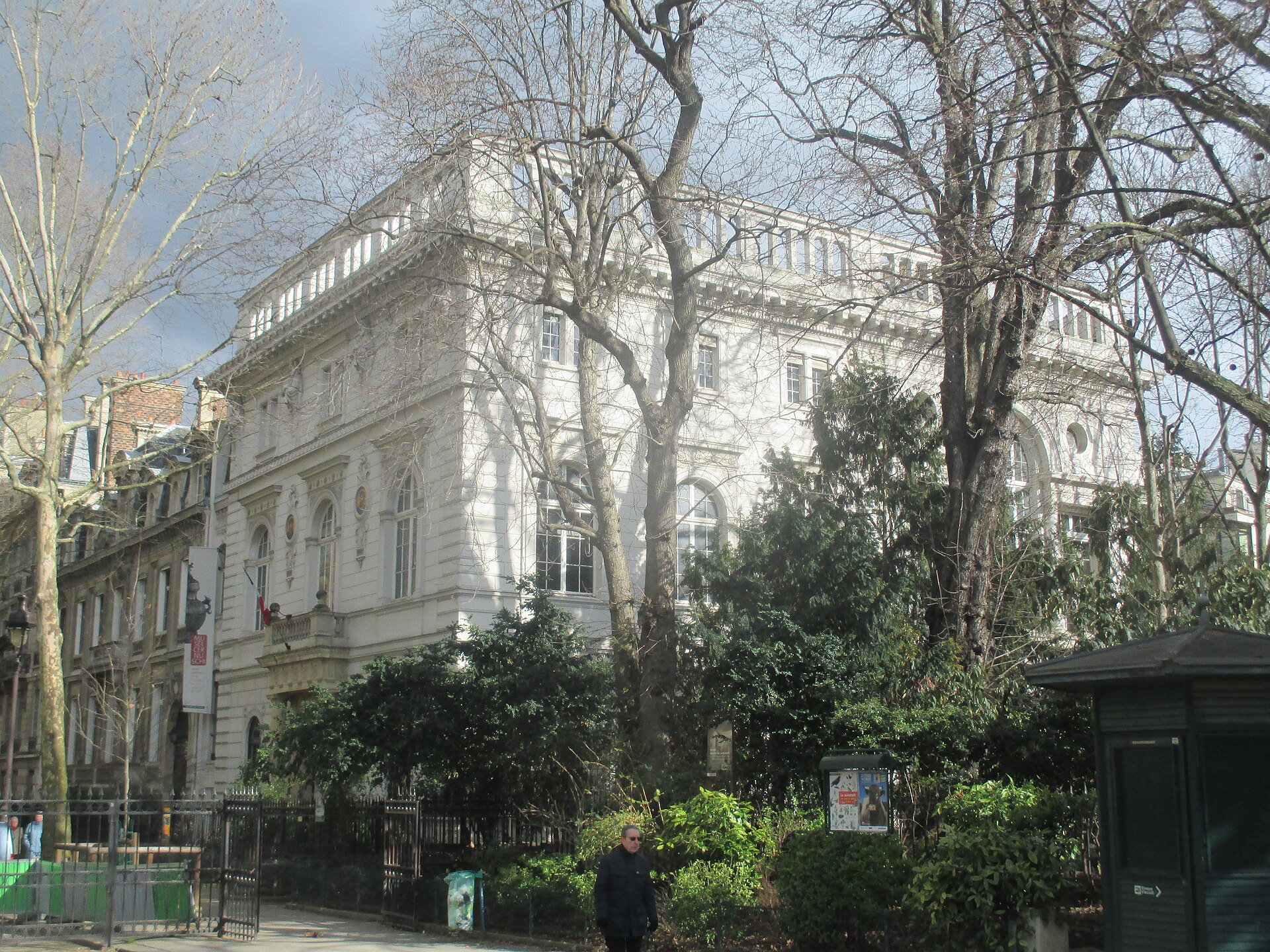 la villa del musee cernuschi vista di scorcio dal parc monceau, con la balaustra sul tetto e gli alberi spogli davanti