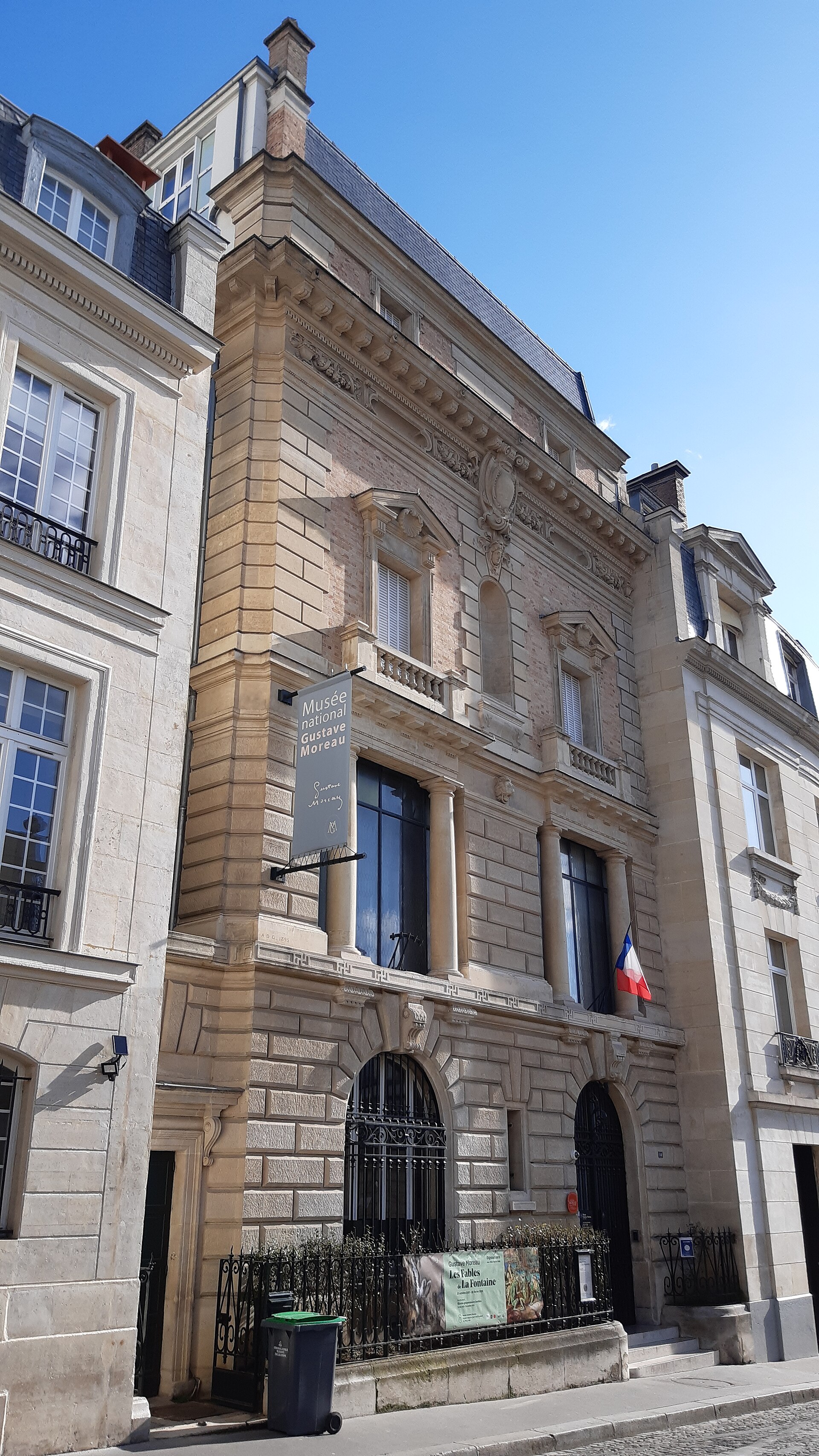 la facciata in pietra del musee gustave moreau in rue de la rochefoucauld, con lo stendardo del museo e la bandiera francese