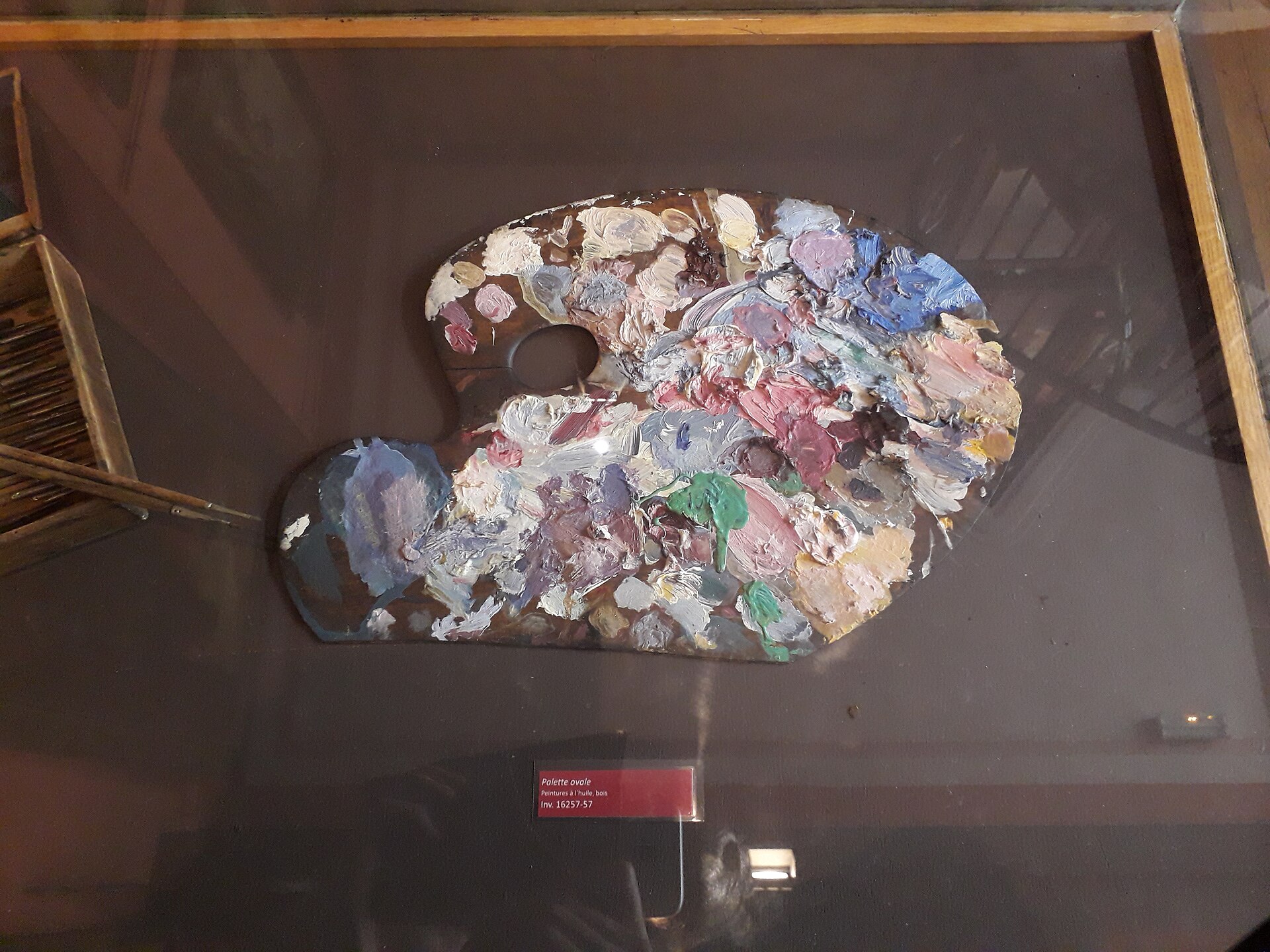 la palette ovale di gustave moreau in vetrina, coperta di colori a olio secchi bianchi rosa azzurri e verdi