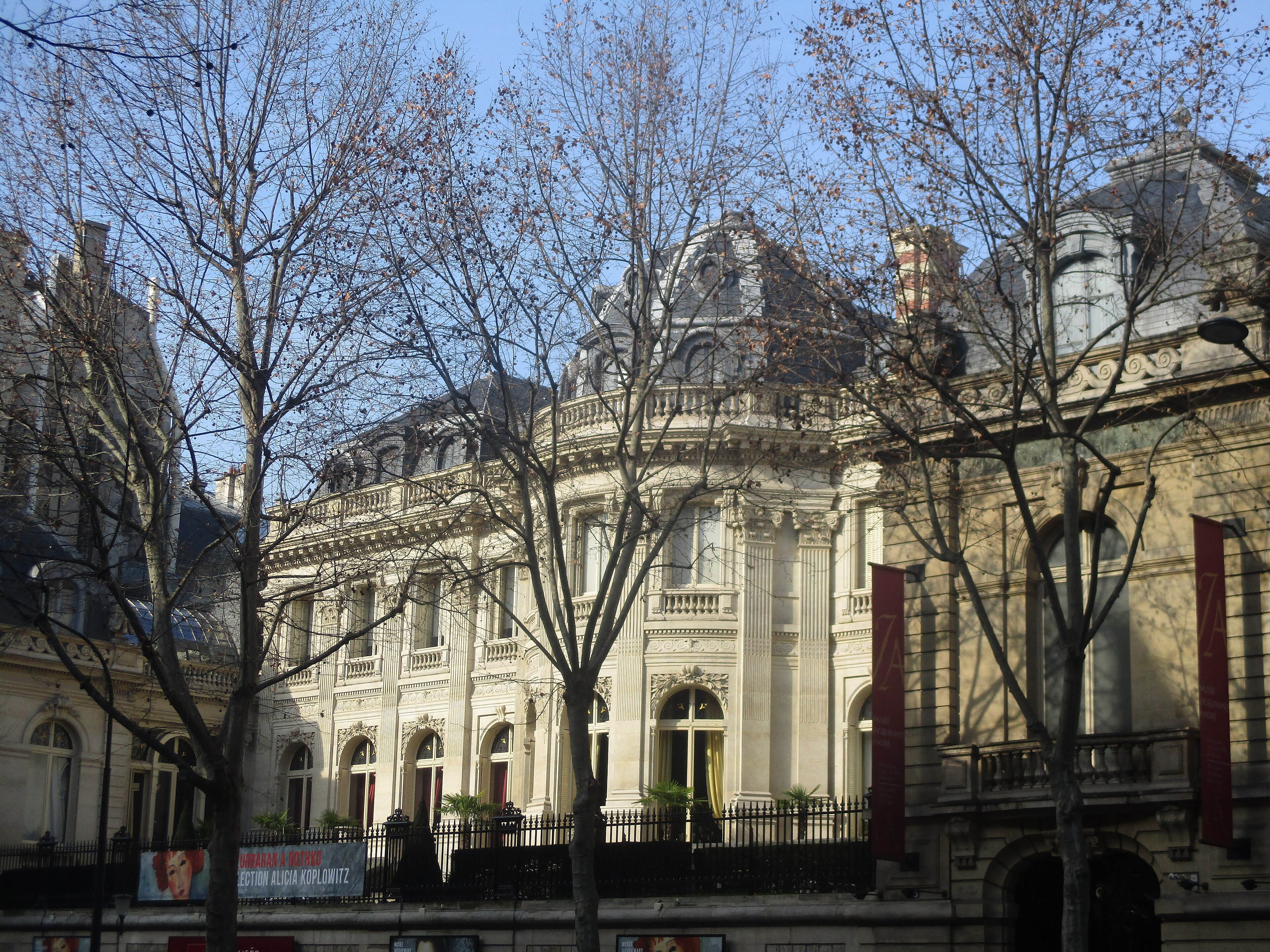 la facciata in pietra chiara del musee jacquemart andre sul boulevard haussmann, con le alte finestre ad arco e la cancellata nera con le punte dorate