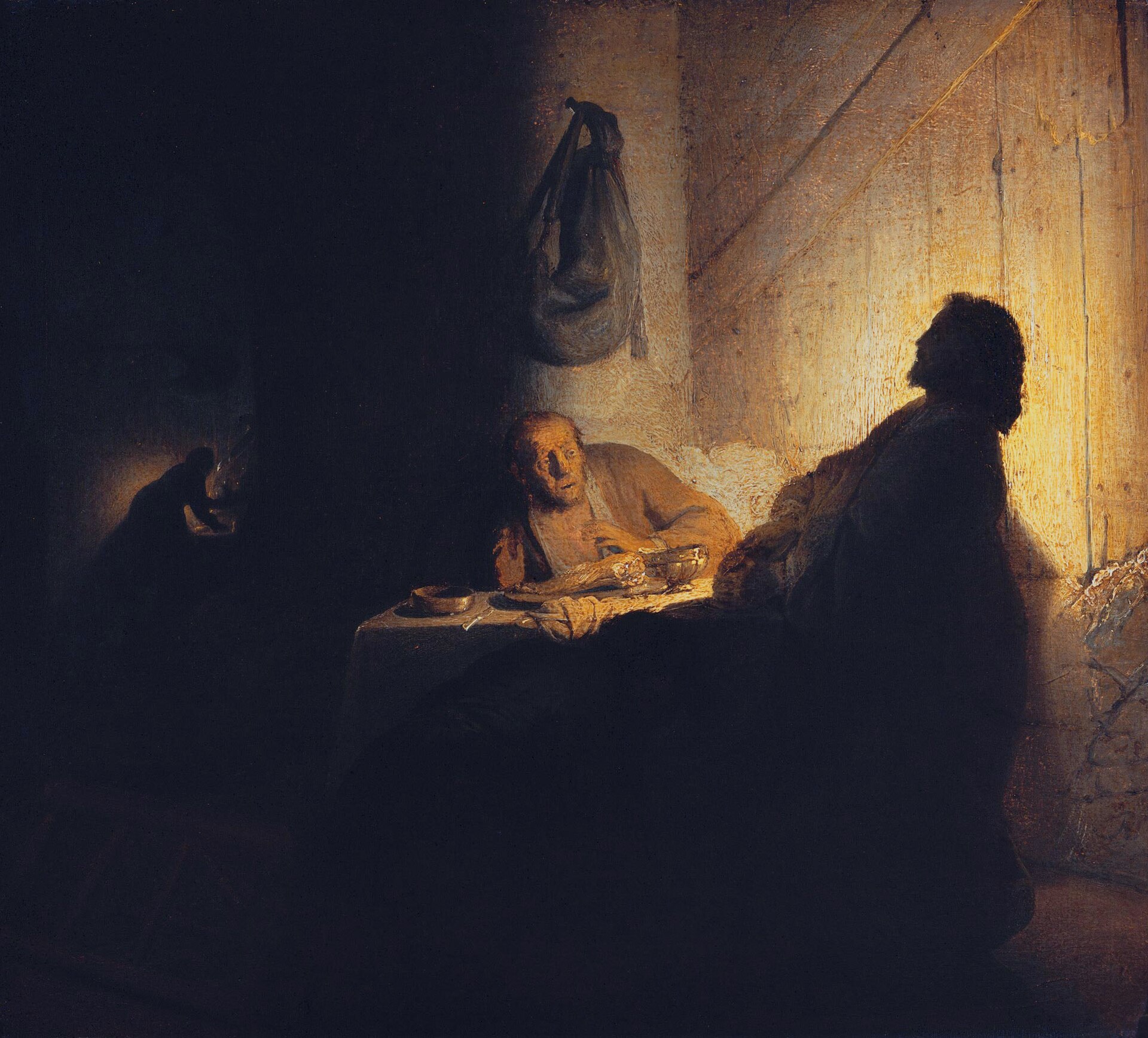 i pellegrini di emmaus di rembrandt, con cristo di profilo in controluce a destra e il discepolo seduto al tavolo a sinistra