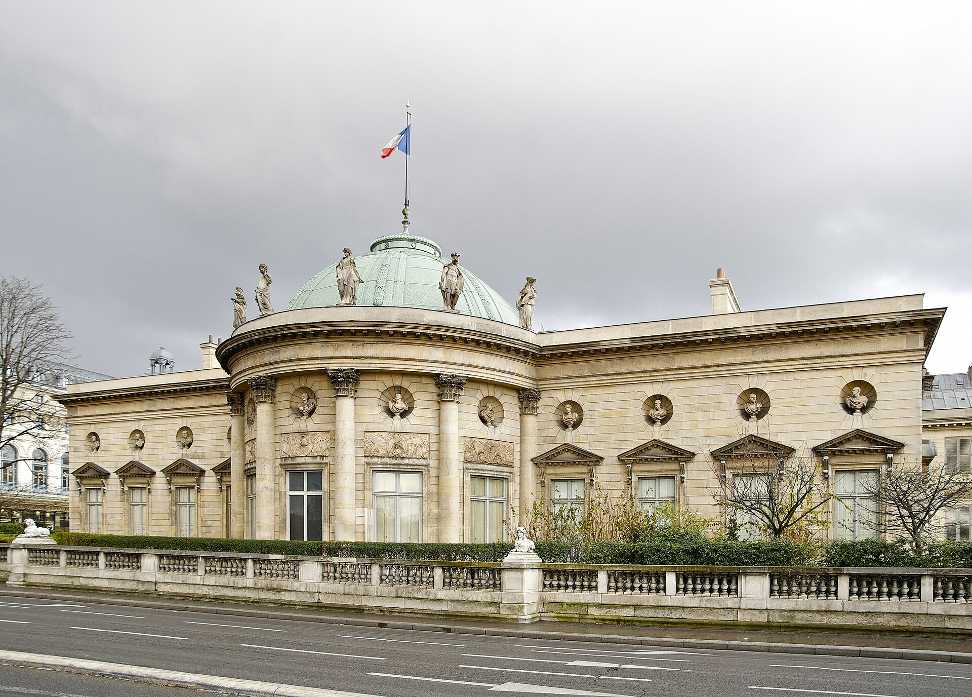 la facciata dell hotel de salm sul lungosenna, con il corpo centrale a rotonda scandito da colonne corinzie, la cupola di rame verde sormontata dalla bandiera francese, le statue sulla balaustra del tetto e i busti dentro nicchie circolari lungo tutta la facciata