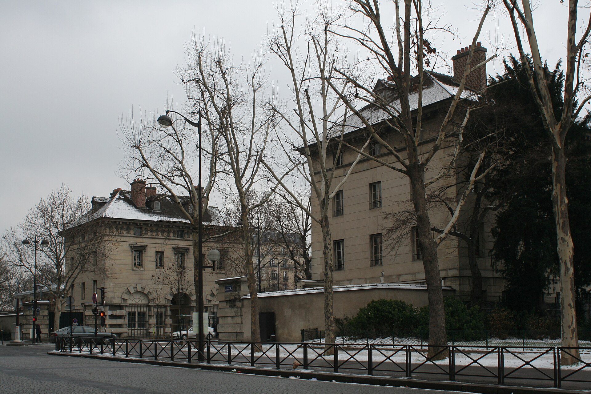 the two ledoux pavilions on place denfert-rochereau in winter, with bare plane trees and snow on the ground