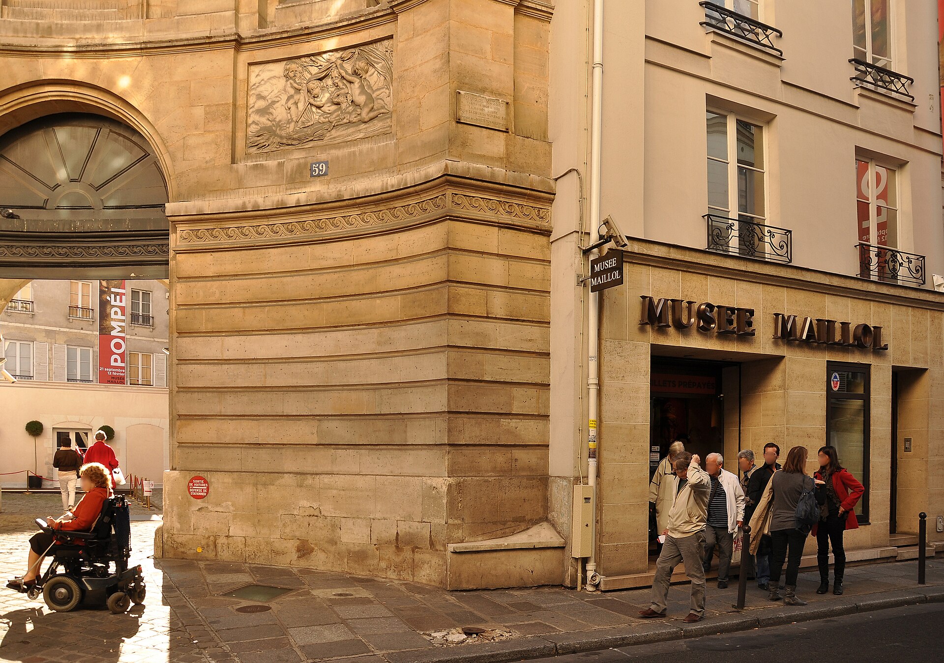 l entree du musee maillol rue de grenelle, avec les lettres en relief au-dessus de la porte et a gauche le flanc de pierre de la fontaine des quatre-saisons avec un relief de putti