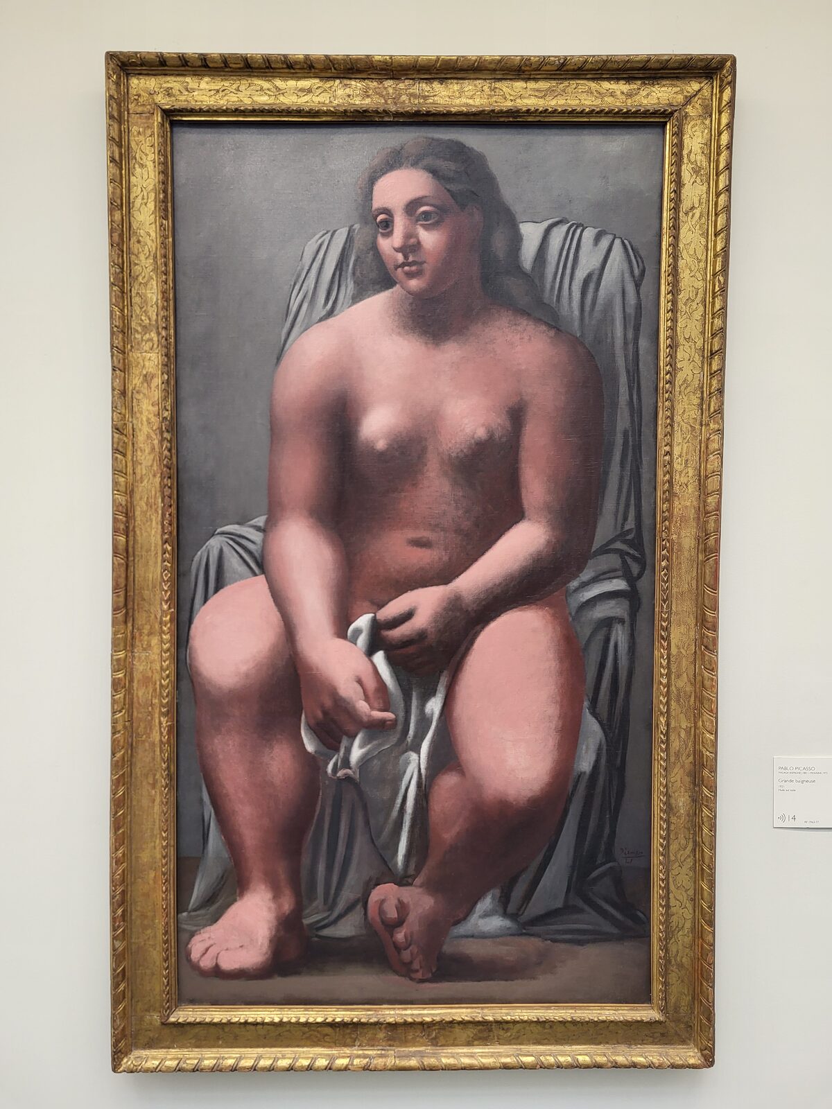 la Grande bagnante di Picasso del 1921, una donna seduta di grandi proporzioni con un panno bianco in grembo