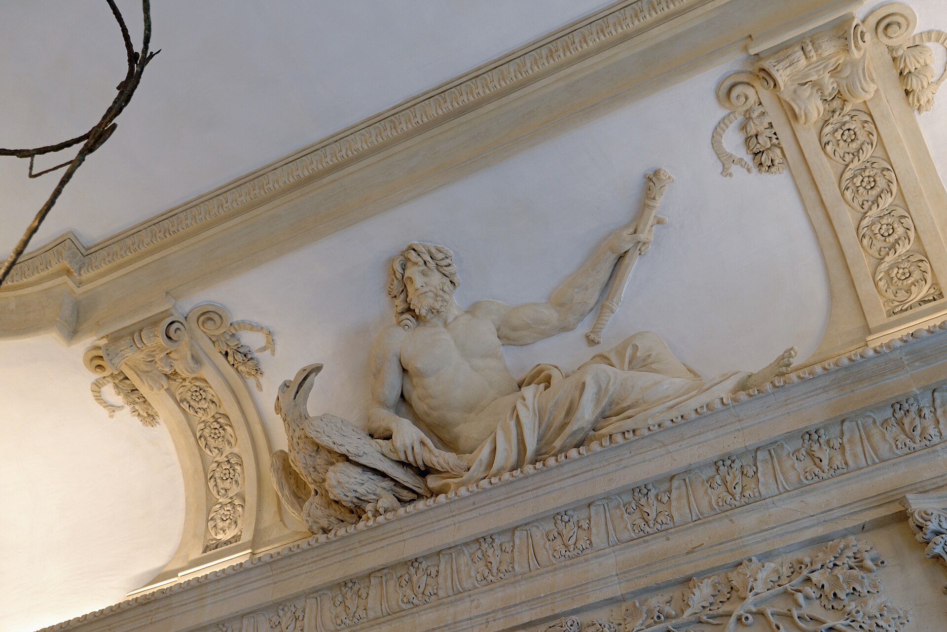 stucco dello scalone dell hotel sale, un uomo barbuto sdraiato sulla cornice con un aquila accanto e il braccio alzato