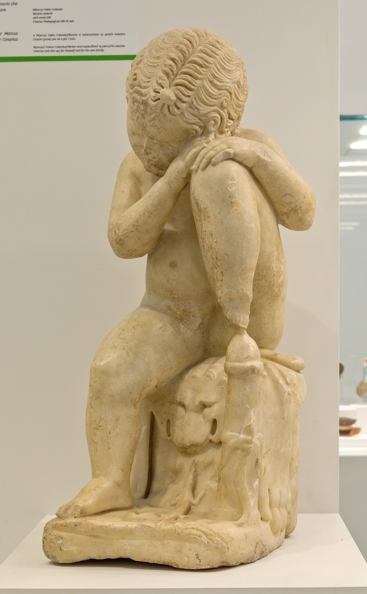 statua romana di eros dormiente in marmo appoggiato a una roccia