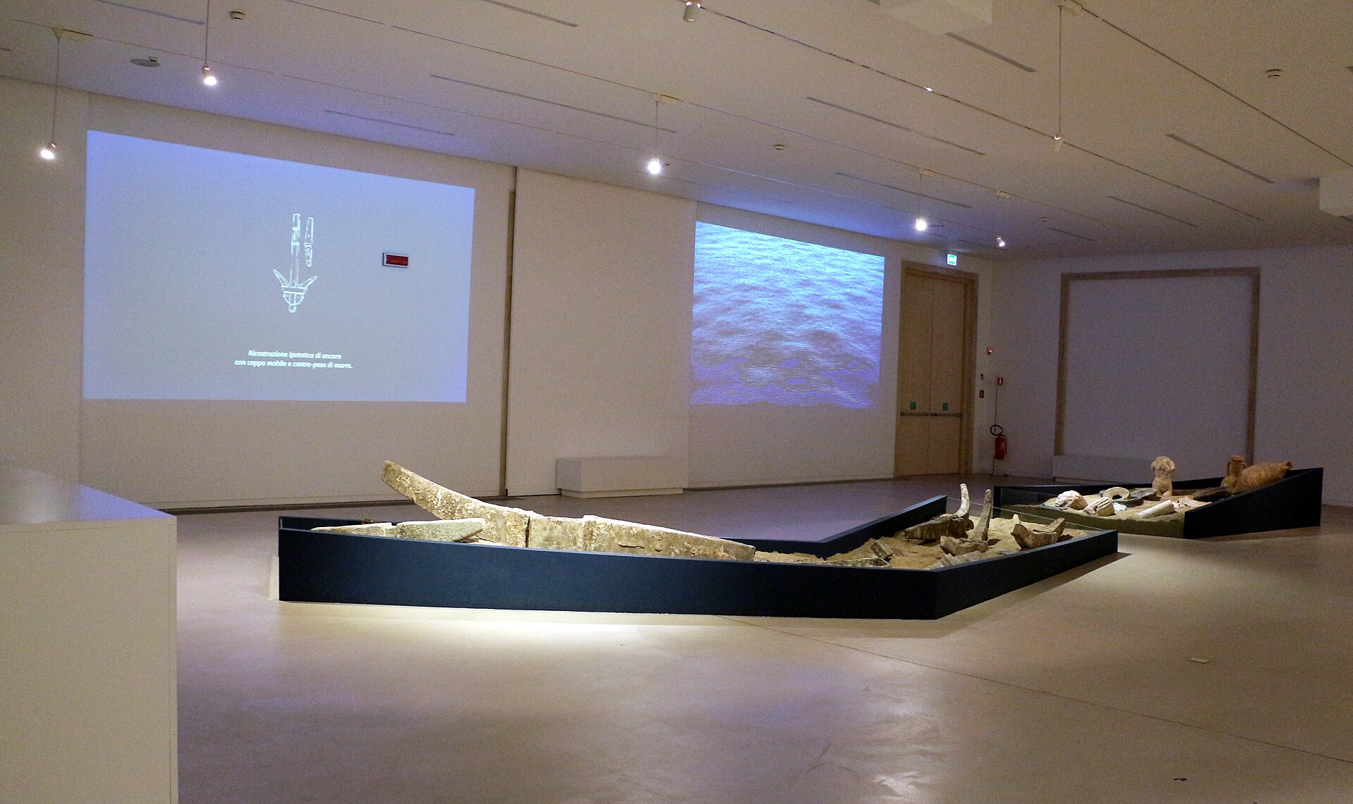 la sala dei relitti del museo archeologico di reggio calabria con le due imbarcazioni antiche e le proiezioni sul muro