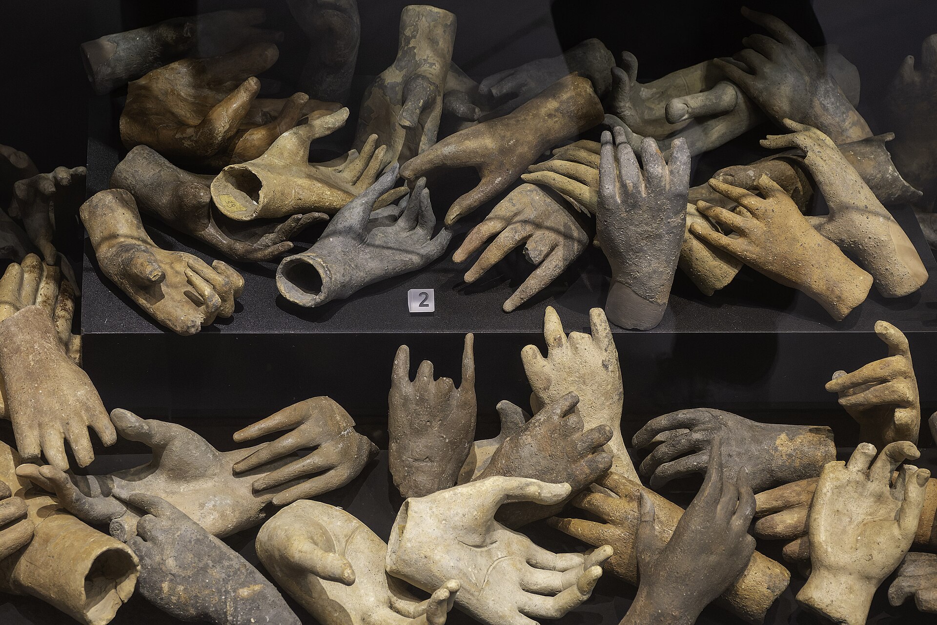 vetrina con decine di mani e avambracci votivi in terracotta al museo archeologico di cagliari