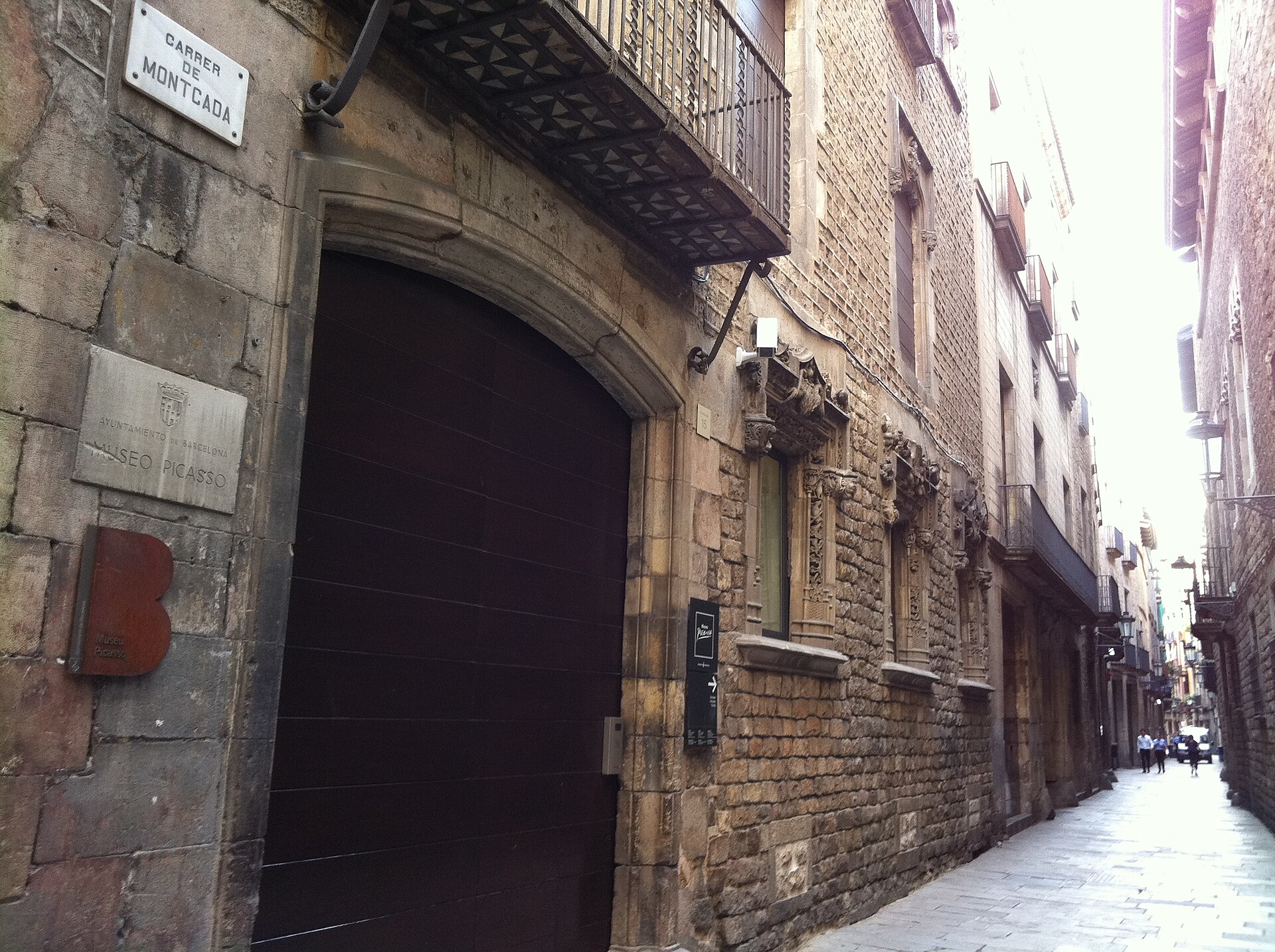 l’ingresso del museu picasso in carrer montcada, con il portone ad arco del palau aguilar e la strada stretta di case medievali che prosegue