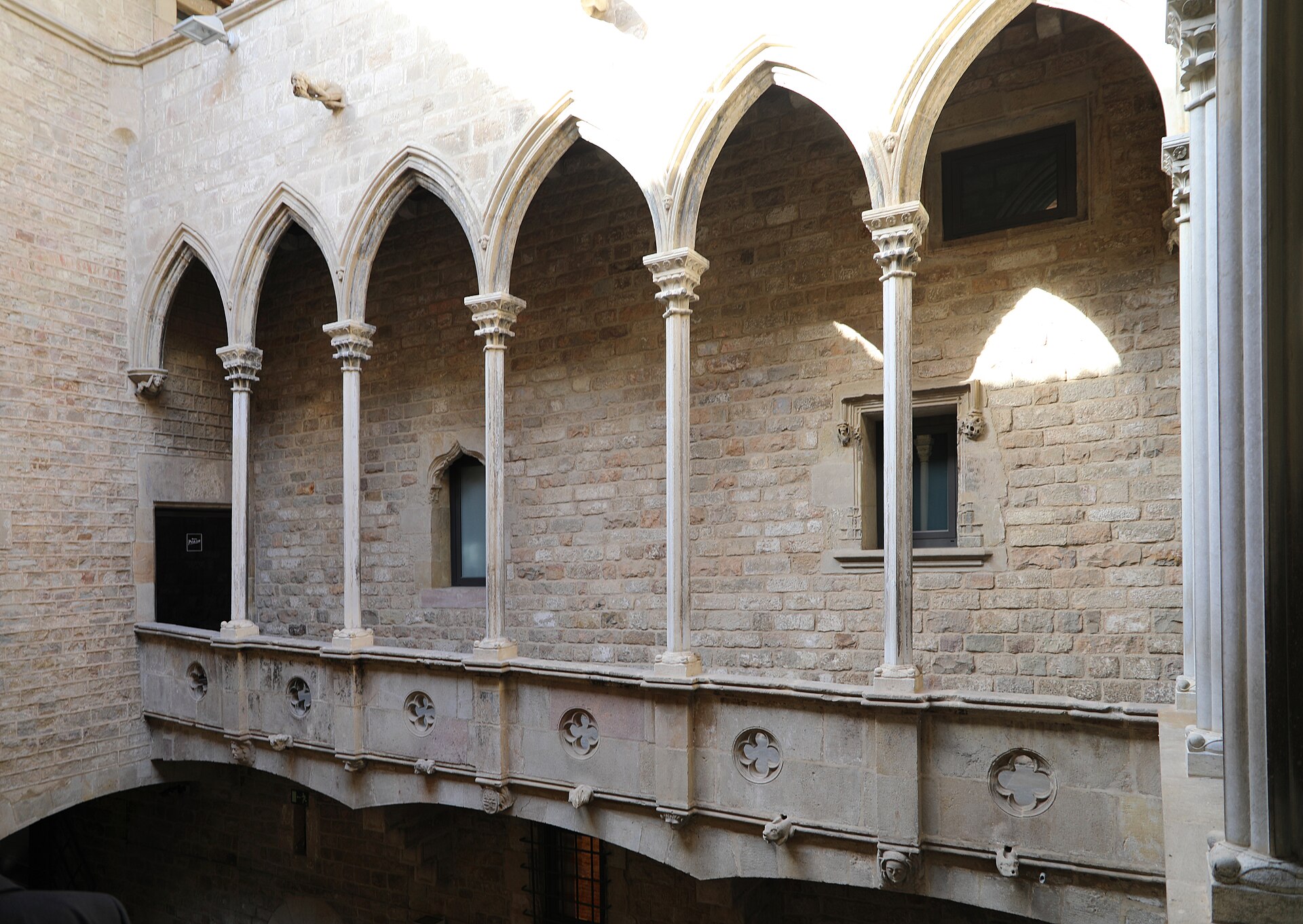 la loggia gotica del cortile del palau aguilar, sede del museu picasso, con gli archi acuti su colonnine sottili e il parapetto di pietra traforata