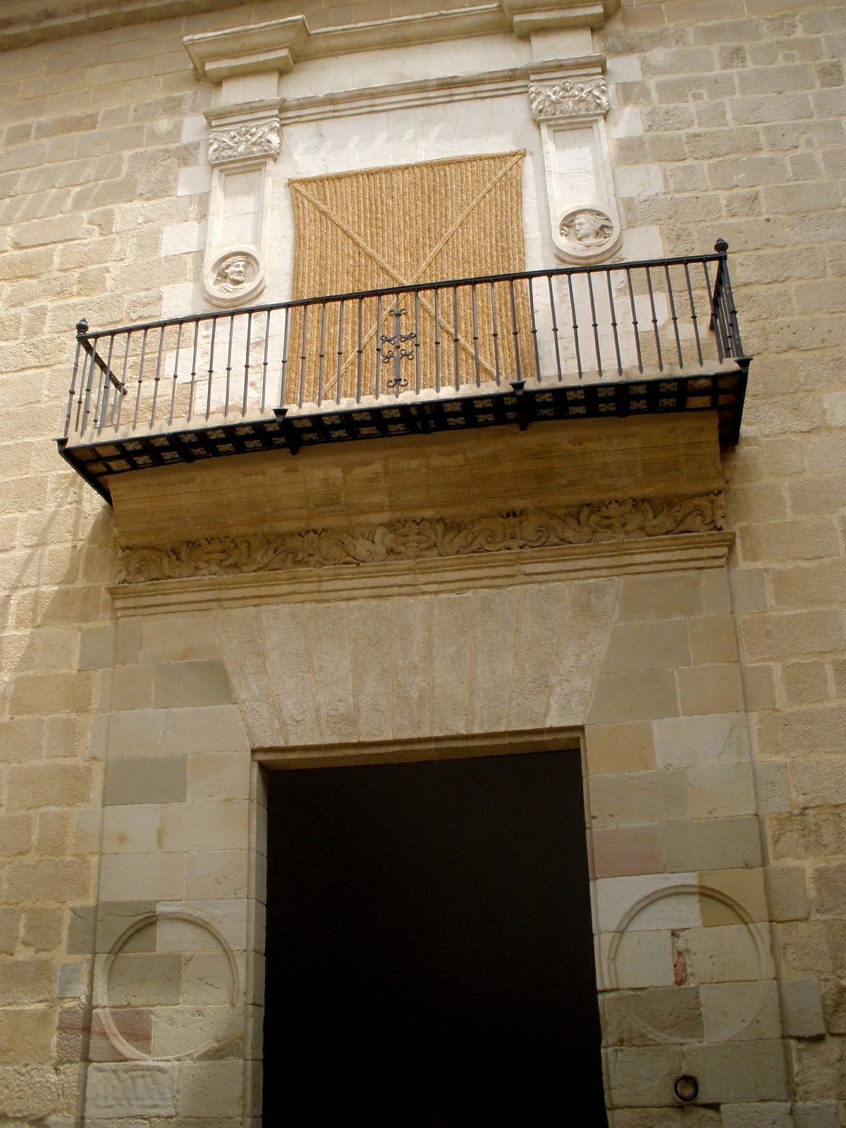 il portale di pietra del palacio de buenavista, con un balcone di ferro sopra la porta