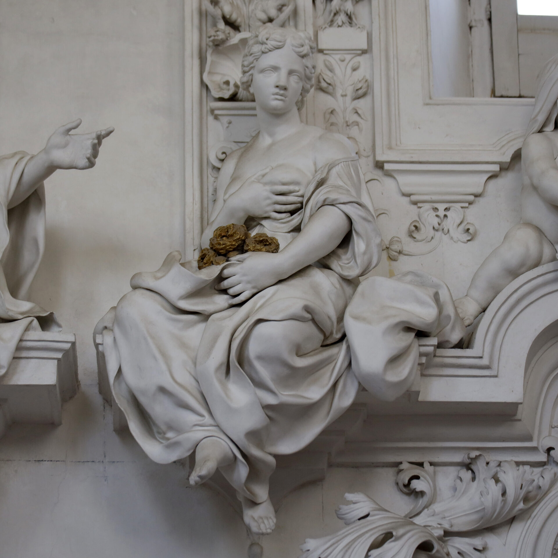 a white stucco allegorical statue by giacomo serpotta seated on a cornice