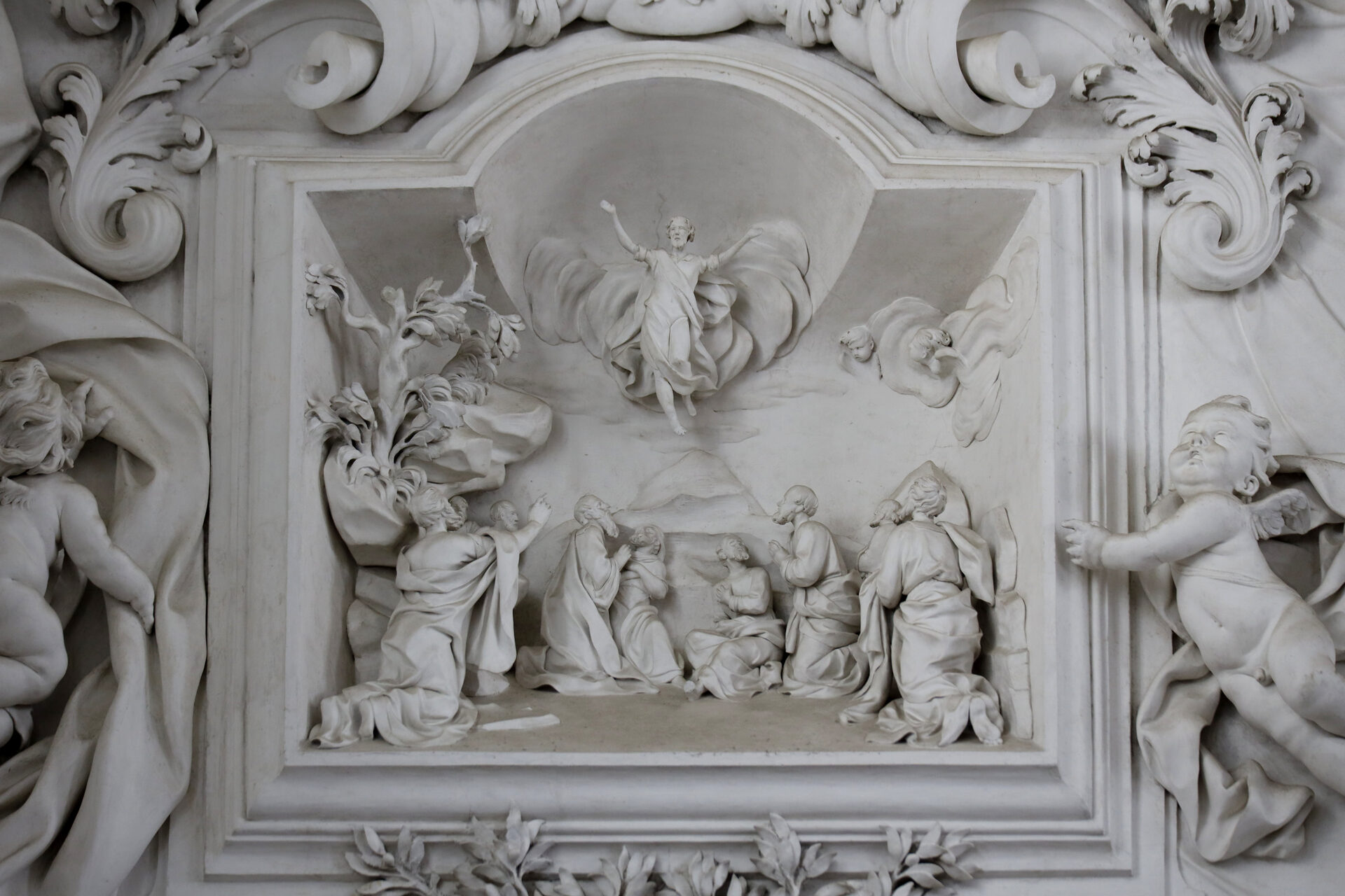 the stucco relief of the ascension in the oratory of santa cita within its frame of putti