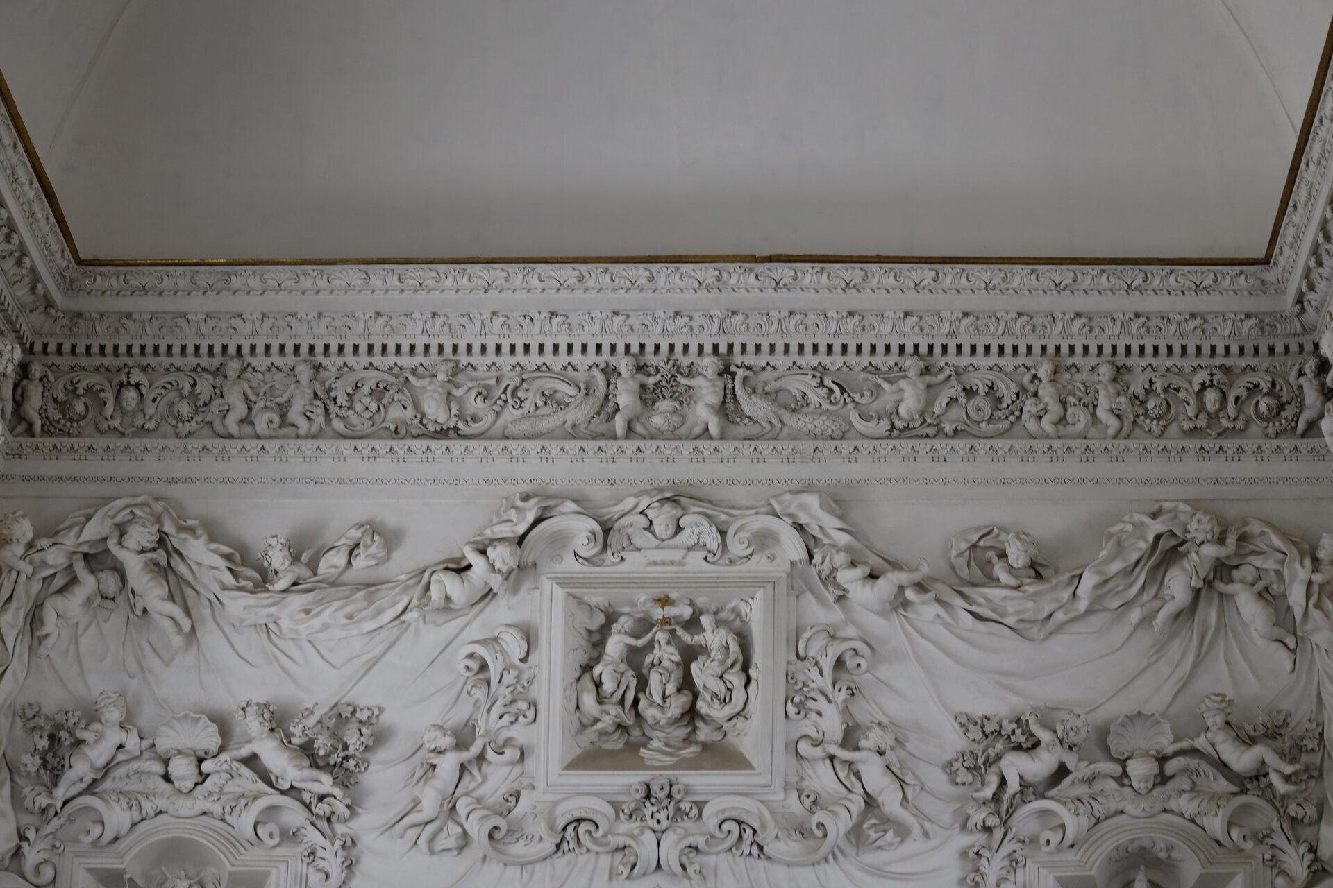 the entrance wall of the oratory of santa cita with the white stucco frieze and the putti