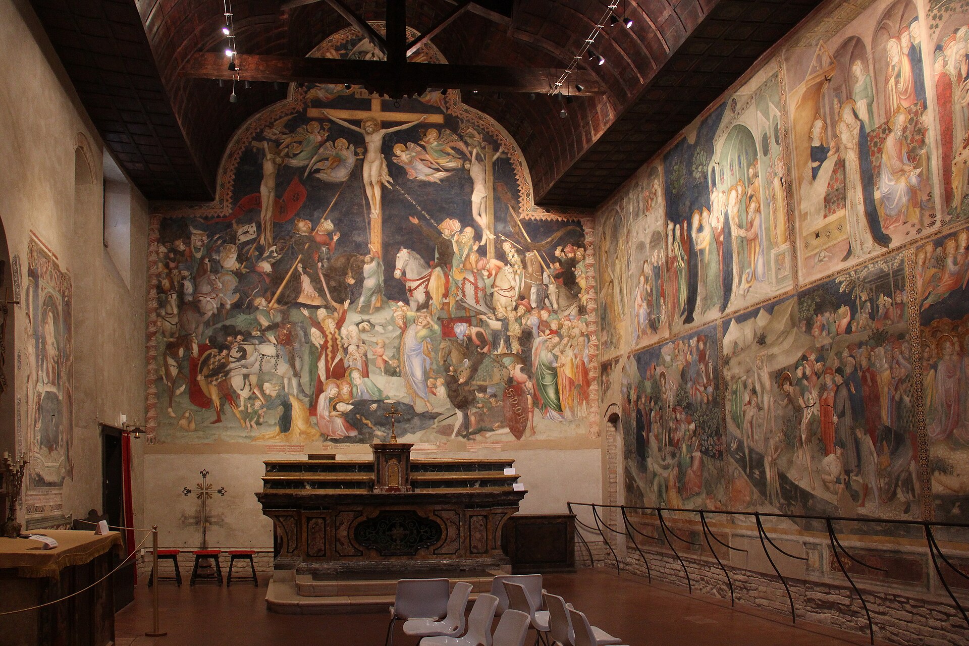 l’intérieur de l’oratoire de san giovanni battista à urbino avec l’autel la crucifixion des salimbeni et le cycle narratif sur le mur de droite