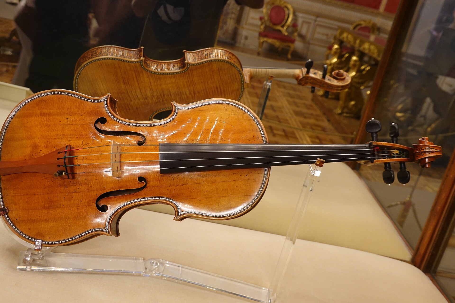 la viola stradivari del 1696 esposta in una vetrina del palacio real di madrid, con il legno color miele, gli intarsi lungo il bordo e il riccio decorato